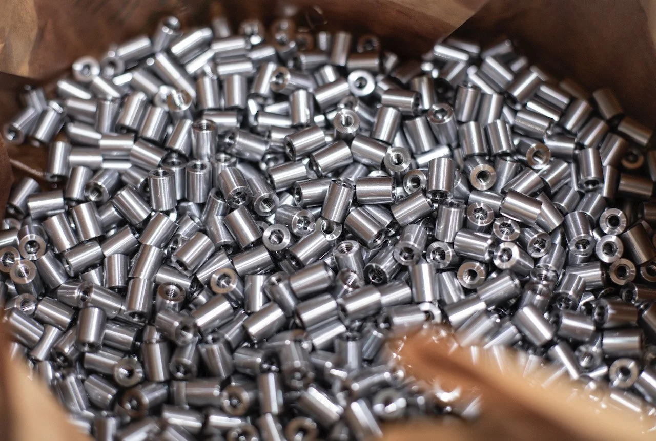 Pile of shiny metal cylindrical beads with holes