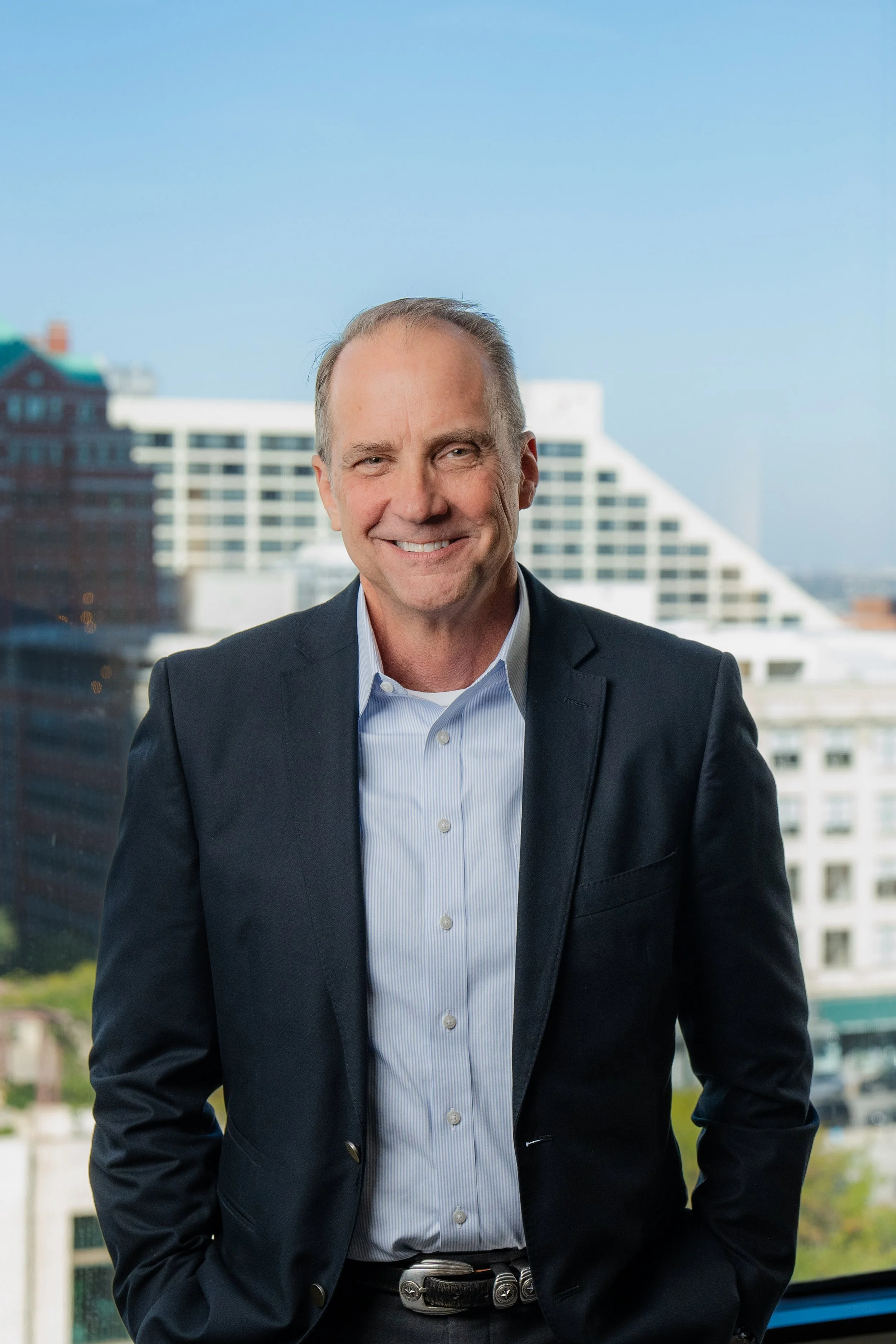 Steve Montgomery Smiling in front of buildings