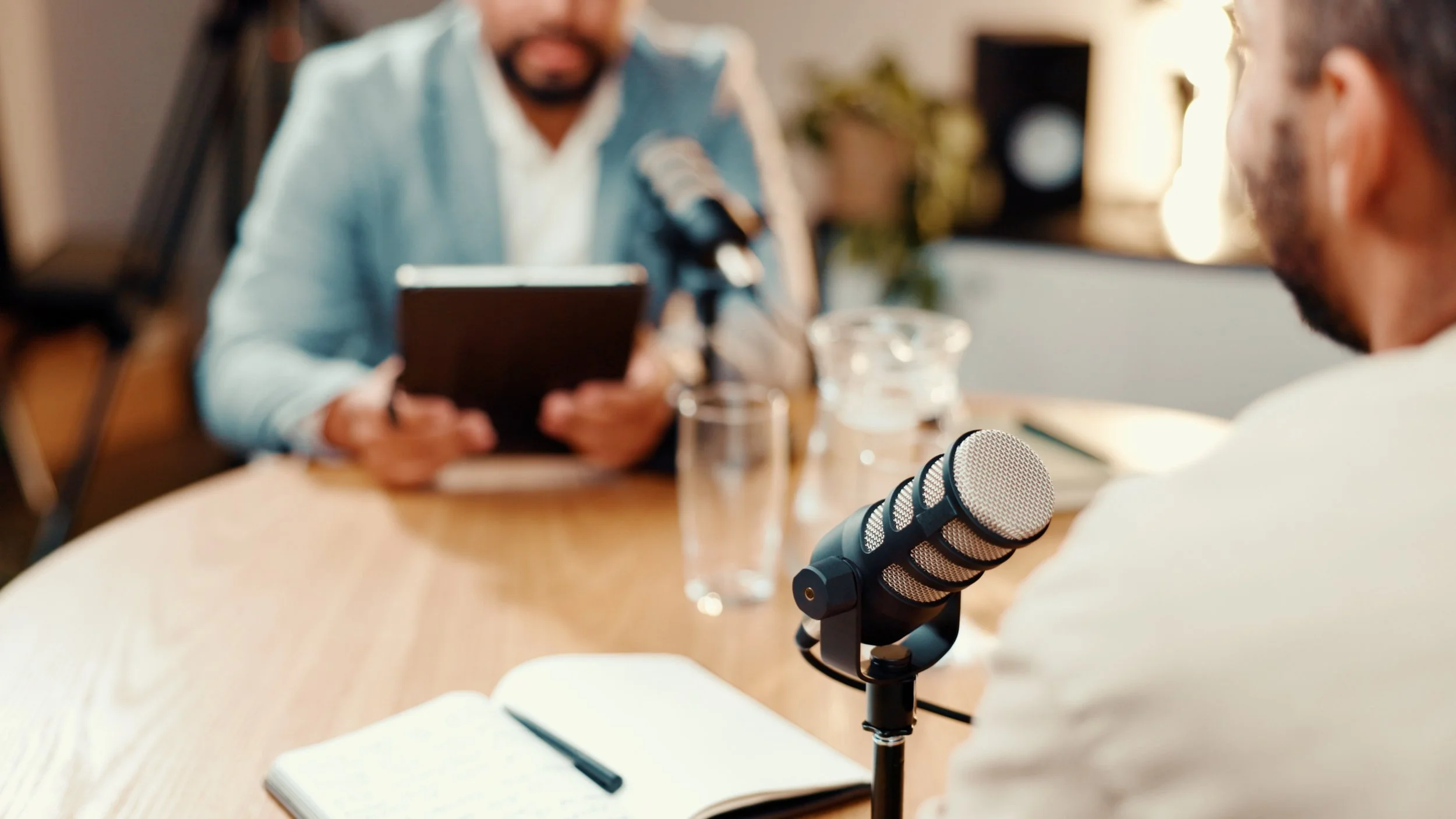 A person speaking into a microphone during a podcast recording, representing earned media and thought leadership