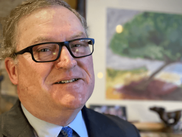 Pete-Lunati, sitting at desk smiling