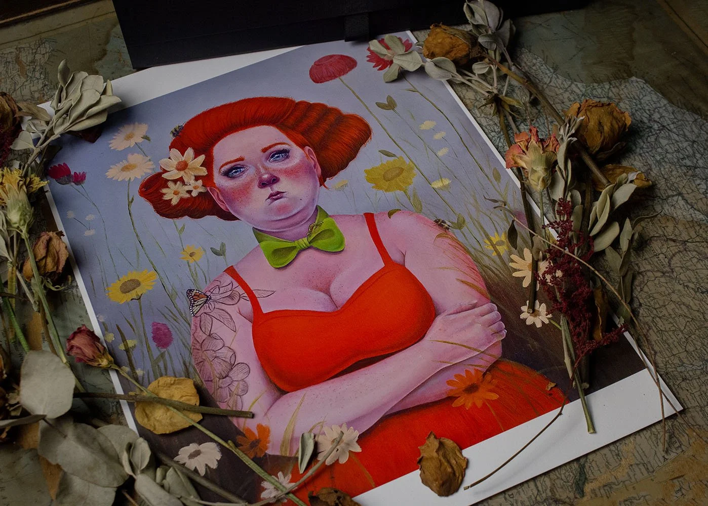 A drawing or painting of a woman with red hair, wearing a red top and a green bow tie, surrounded by flowers and dried leaves.