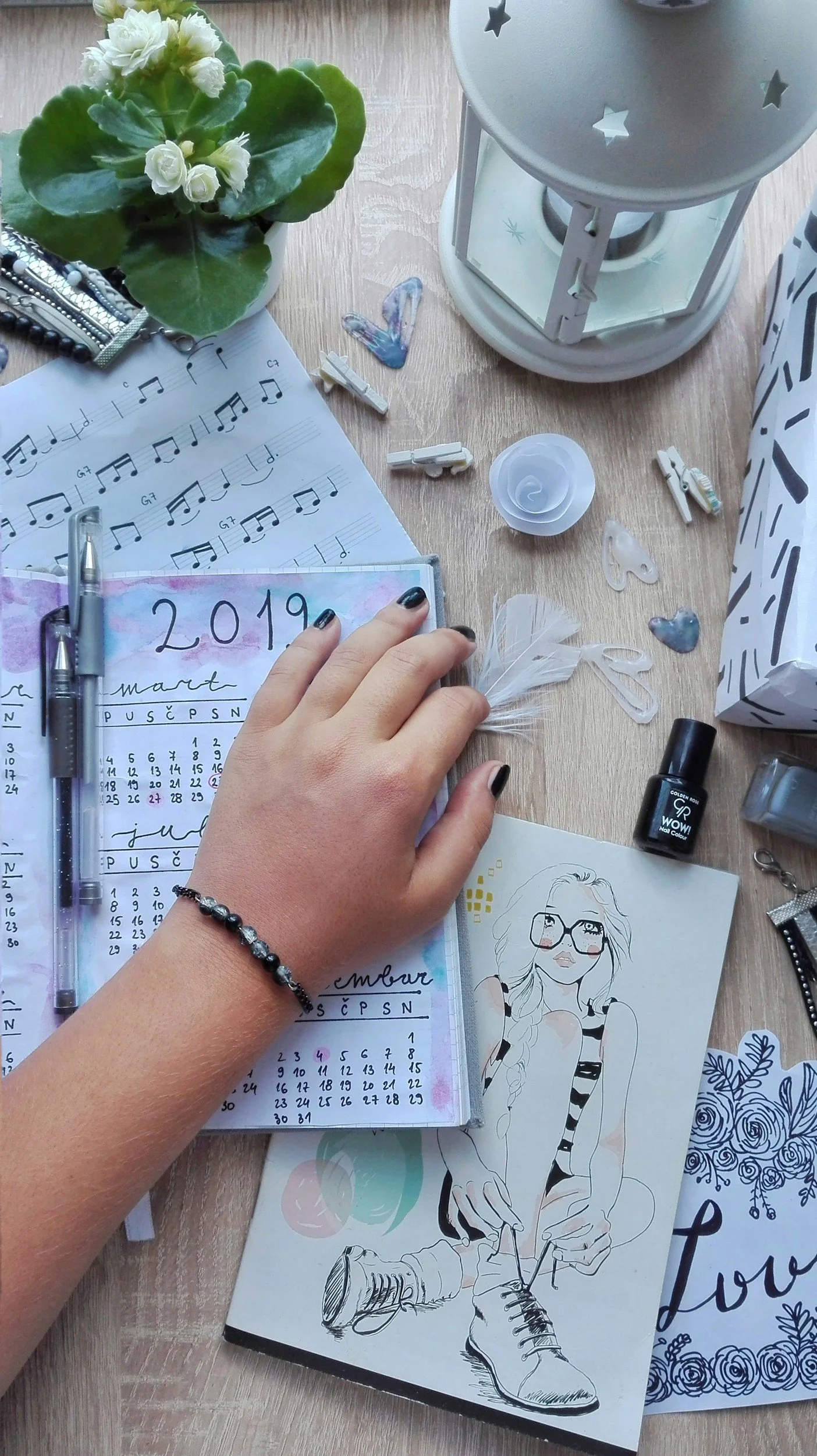 A hand resting on an open calendar on a decorated desk, illustrating planning and external structure.