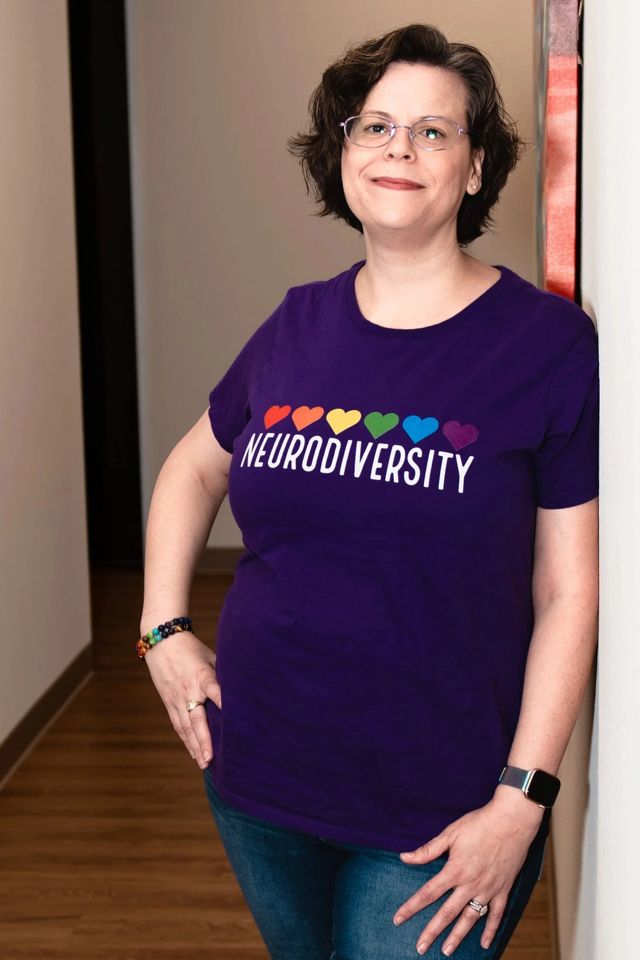 Dr. Christine Henry in a purple neurodiversity shirt with rainbow hearts