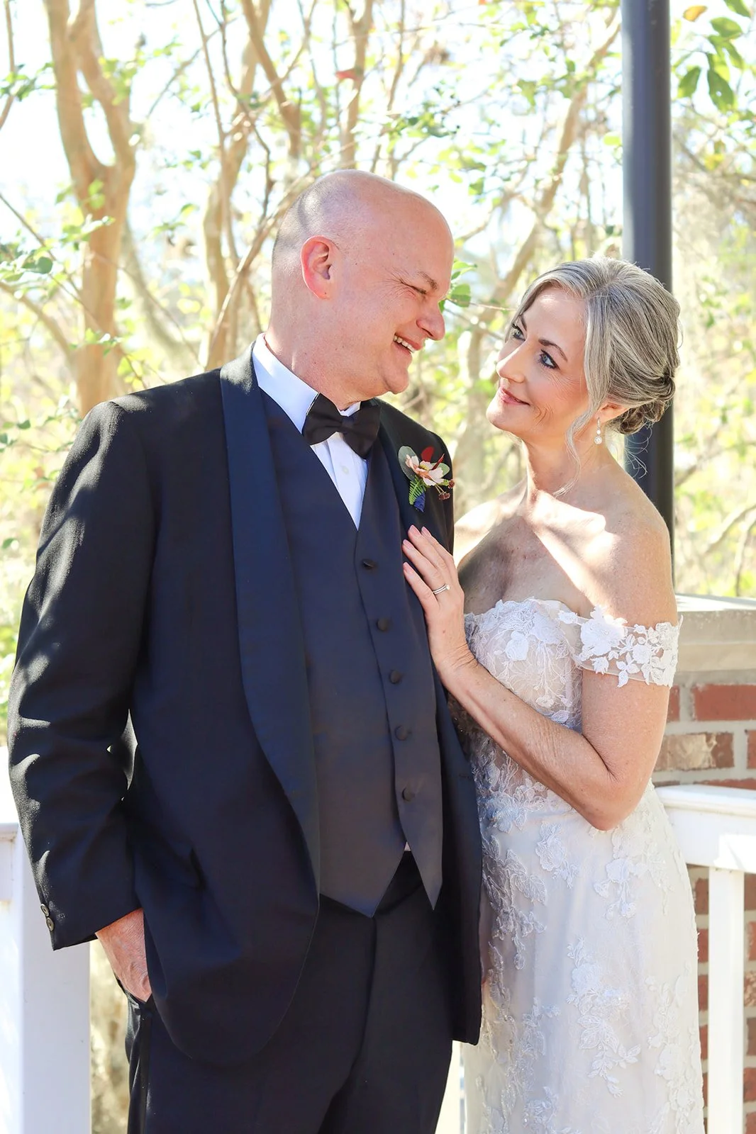 A bride and groom smiling at each other during their wedding.