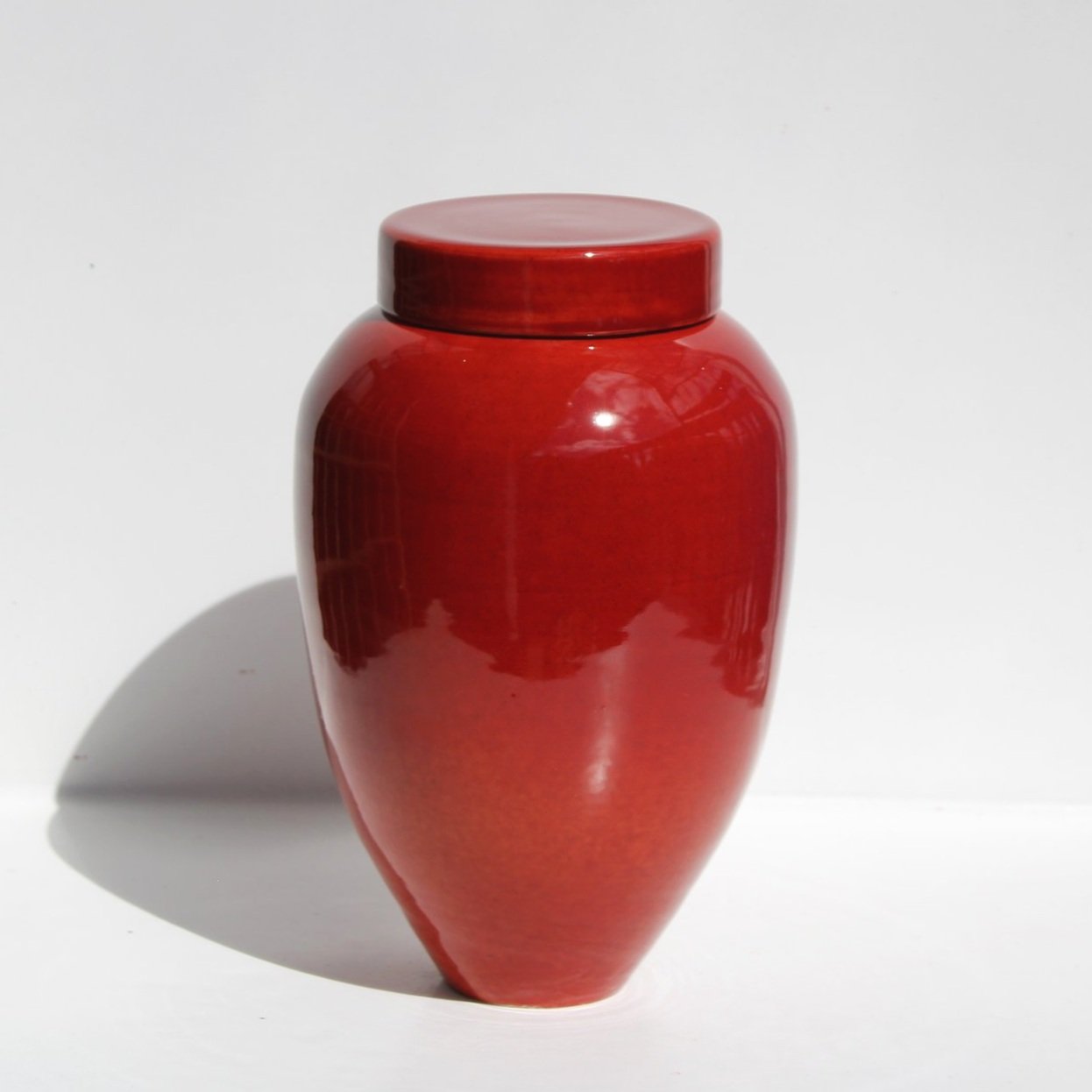 New Zealand handmade ceramic urn with a smooth, glossy glaze in deep blue tones, offering a timeless and elegant memorial option.