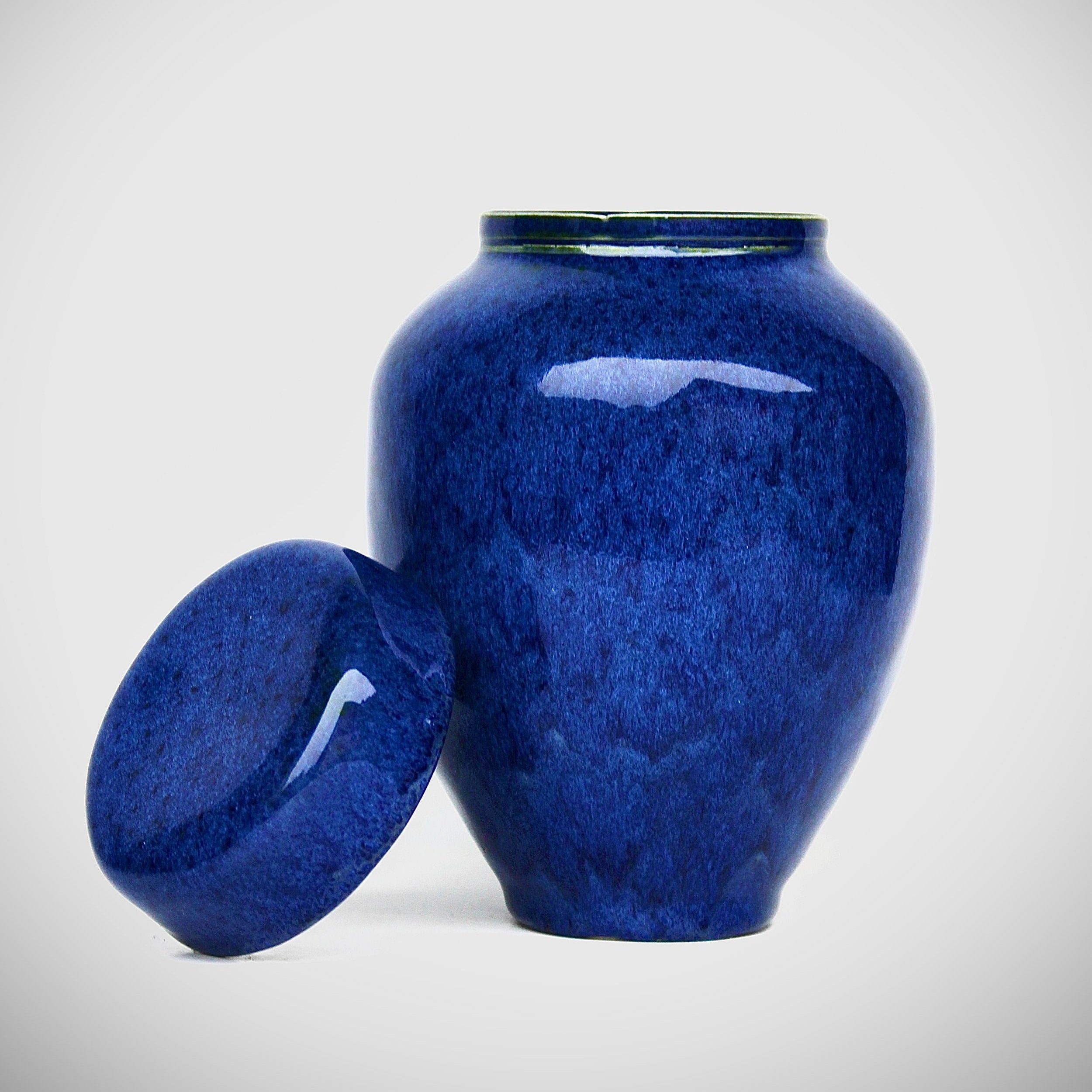 New Zealand handmade ceramic urn with a smooth, glossy glaze in deep blue tones, offering a timeless and elegant memorial option.