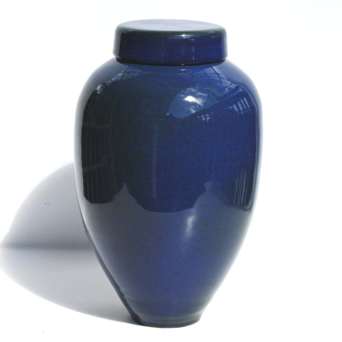New Zealand handmade ceramic urn with a smooth, glossy glaze in deep blue tones, offering a timeless and elegant memorial option.