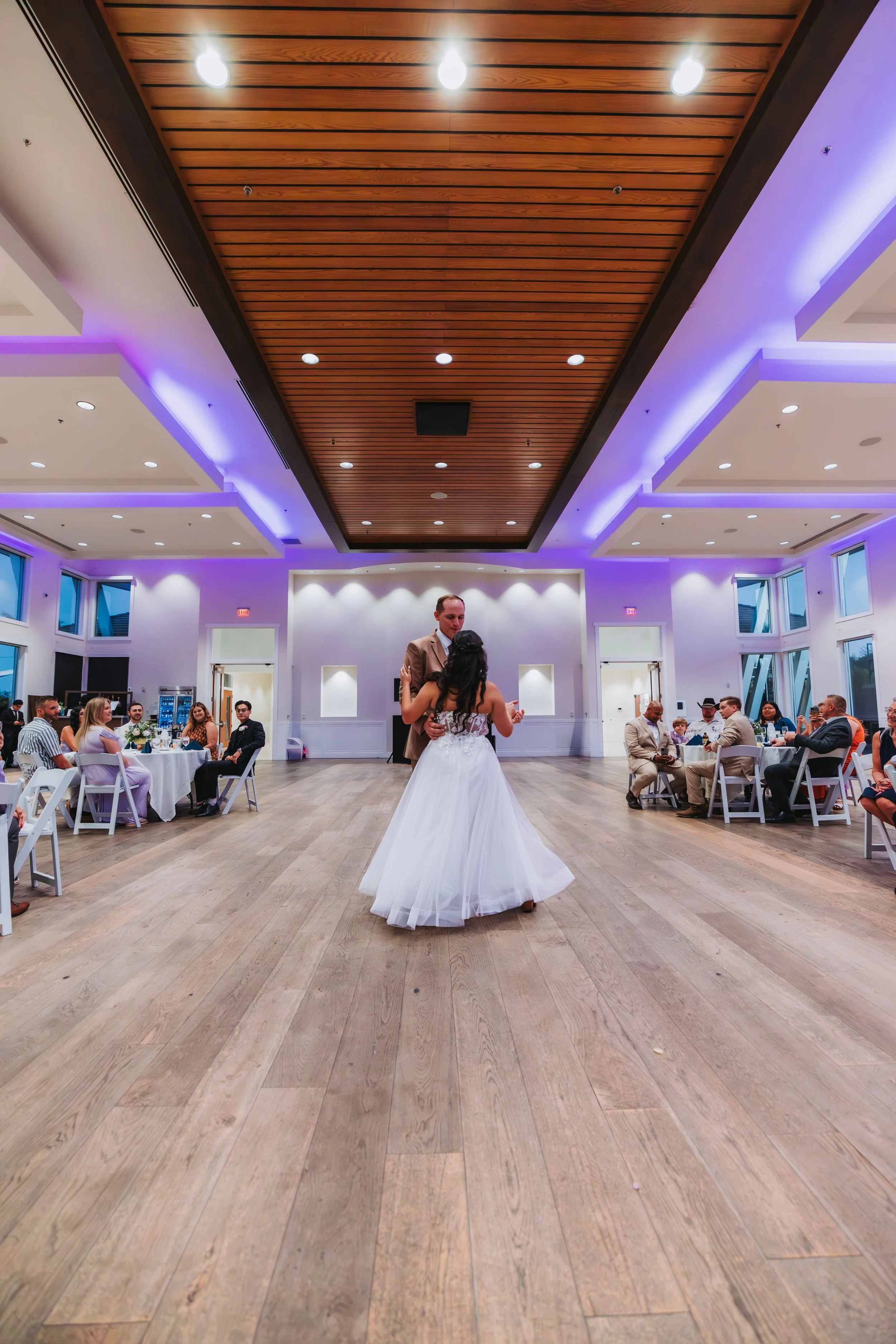 A bride and groom dancing in the center of a decorated reception hall with seated guests around them. engagement wedding photographer phoenix az engagement photographer az traveling wedding photographer az