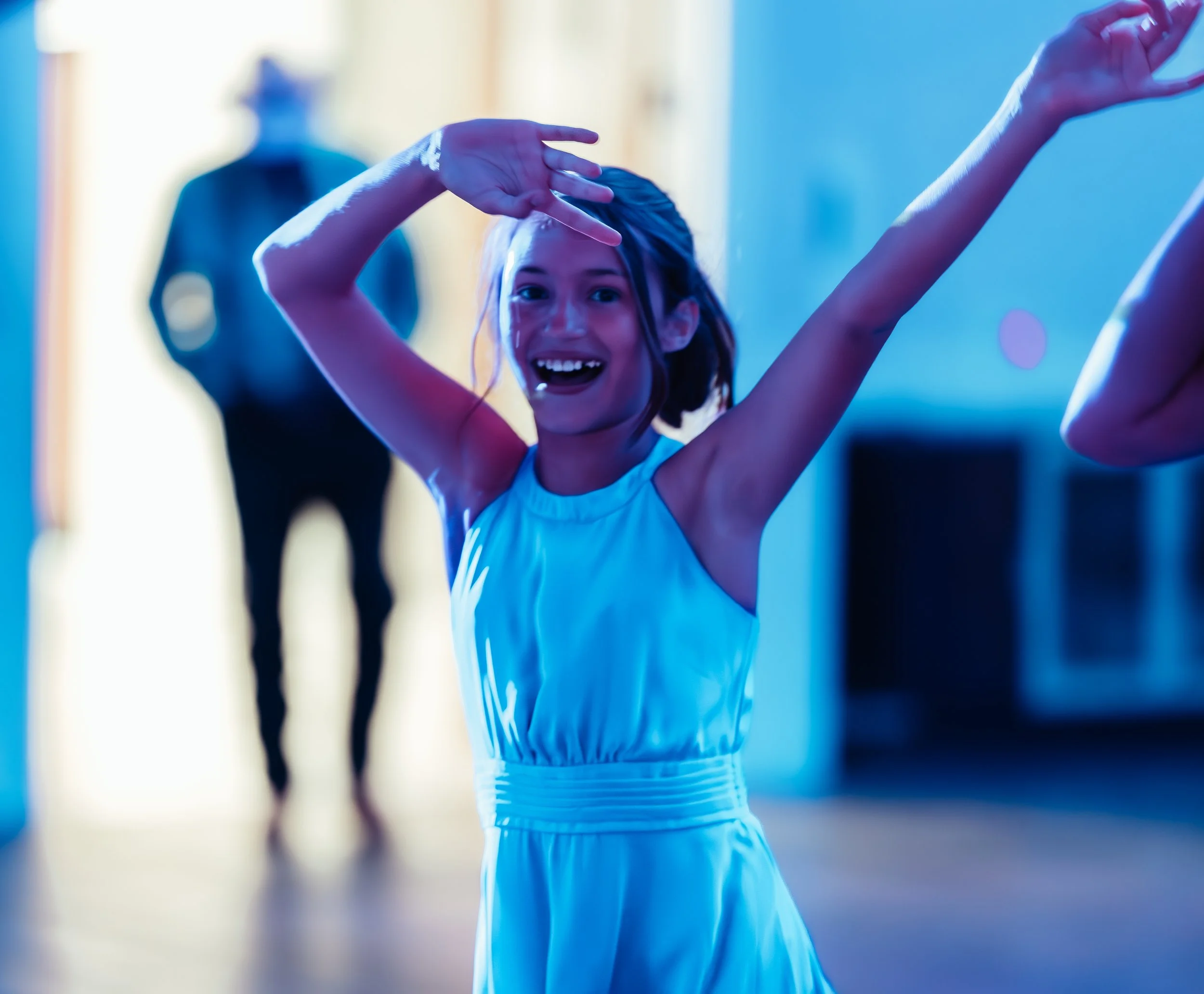Young girl in a white dress dancing in a dance studio with a smiling face and arms raised. western wedding photographer az rustic wedding photographer az barn wedding photographer az backyard wedding photographer az