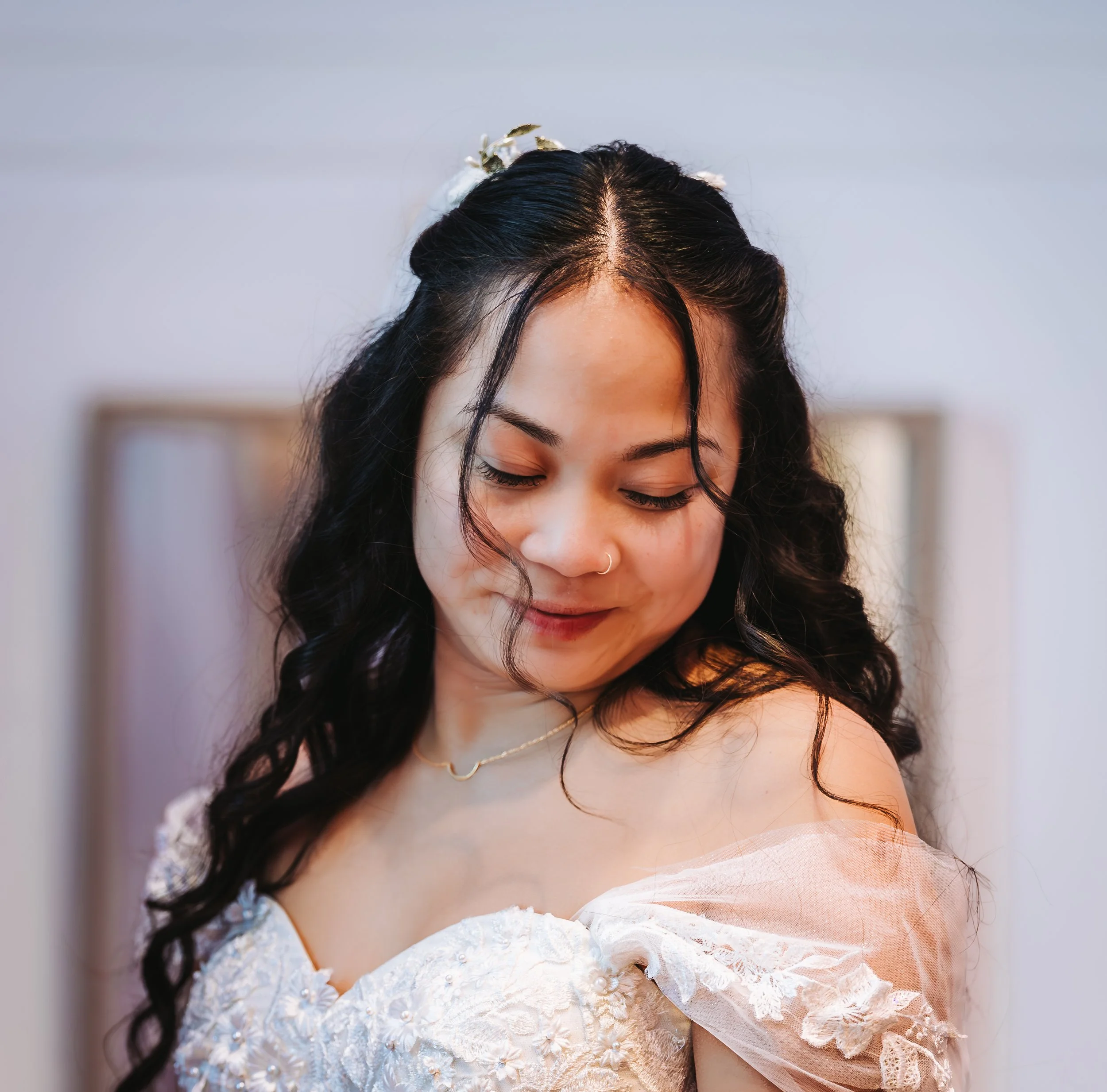 Young woman with long, curly black hair in a wedding dress, looking down and smiling gently. traveling wedding photographer az wedding photographer Prescott az wedding photographer flagstaff az