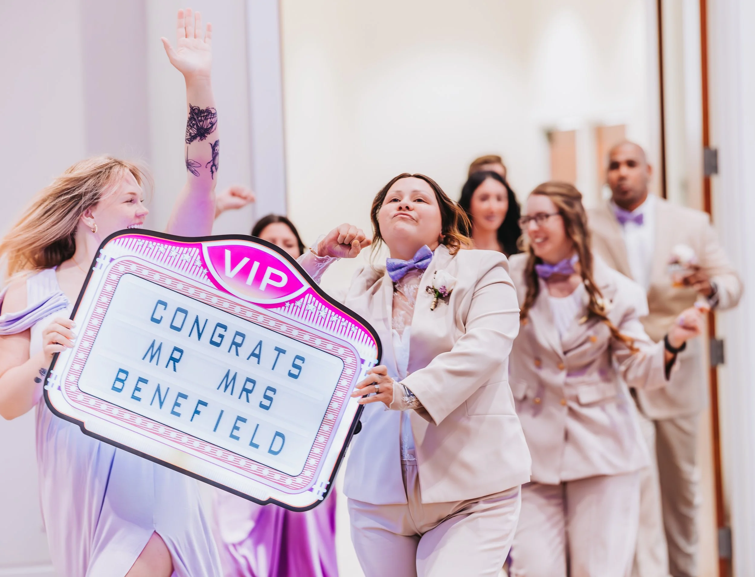 Group of people celebrating at a wedding reception, with a sign that says 'CONGRATS MR & MRS BENEFIELD' and a VIP sign on top. engagement wedding photographer phoenix az engagement photographer az traveling wedding photographer az