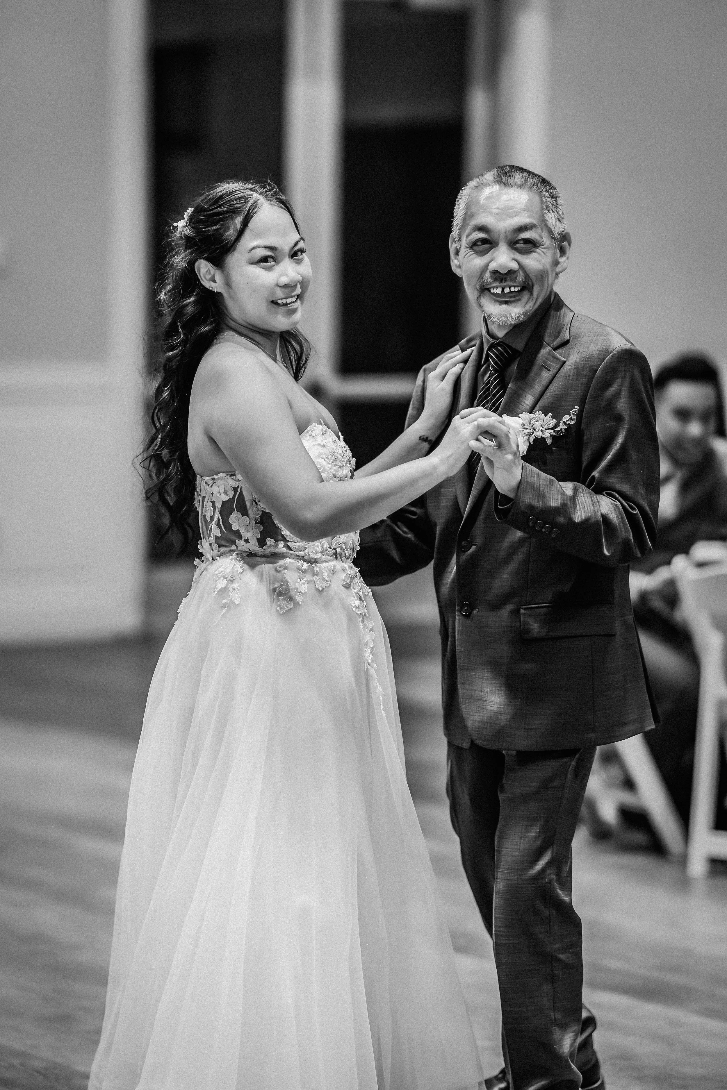 A bride and an older man dancing together at a wedding reception, smiling and holding hands. engagement wedding photographer phoenix az engagement photographer az traveling wedding photographer az