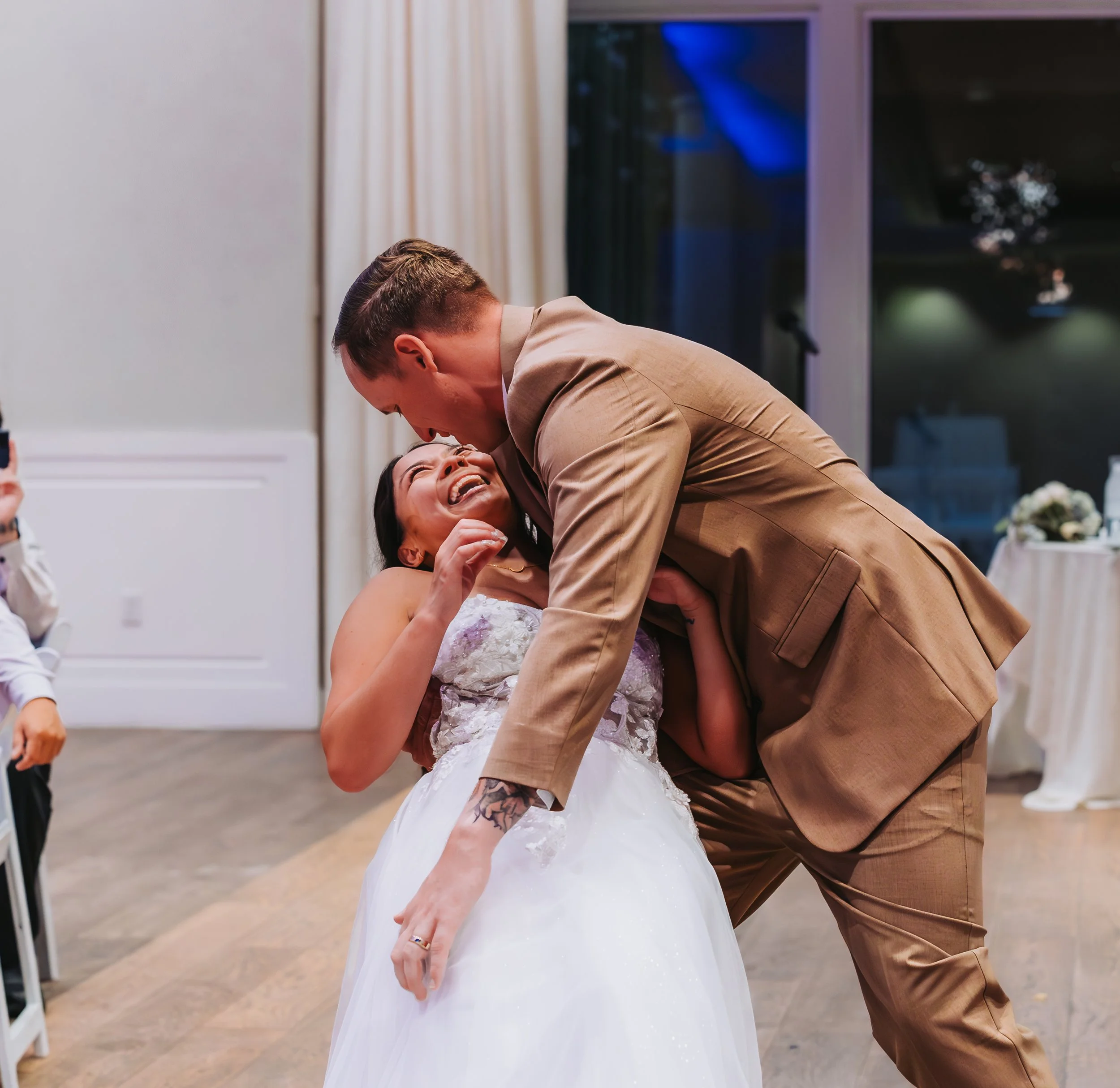 A joyful bride and groom sharing a dance at their wedding reception, with the groom leaning over the bride who is smiling and looking up at him. western wedding photographer az rustic wedding photographer az barn wedding photographer az backyard wedd