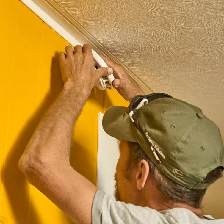 Professional electrician mounting wiring channel near ceiling, emphasizing electrical permits, organized installation, and compliant home electrical improvements.