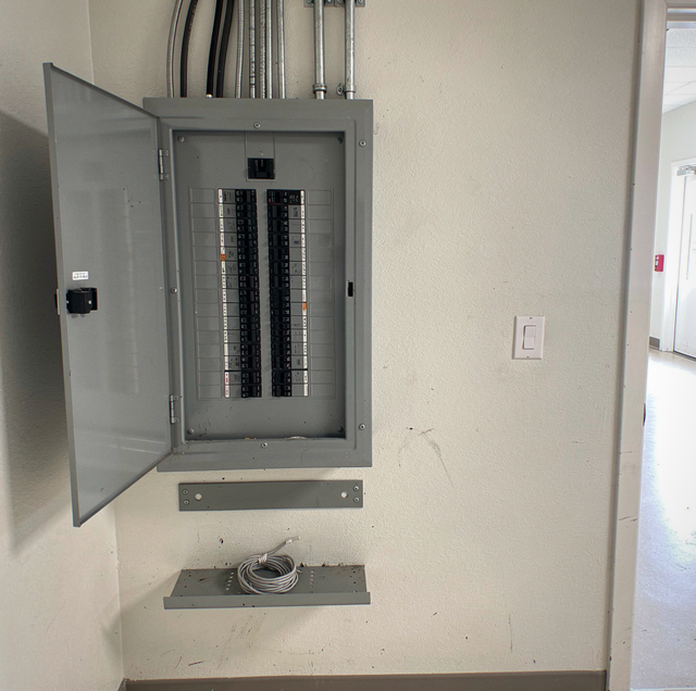 Electrician inspecting commercial electrical panel with thermal camera