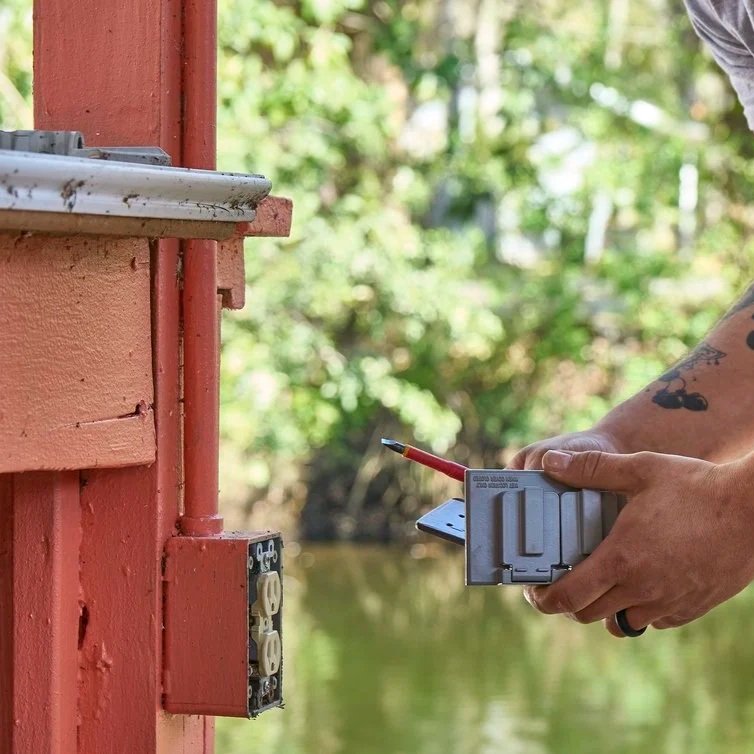 Technician connecting wires inside exterior electrical box during outlet repair, improving safety, preventing faults, and maintaining reliable outdoor power.