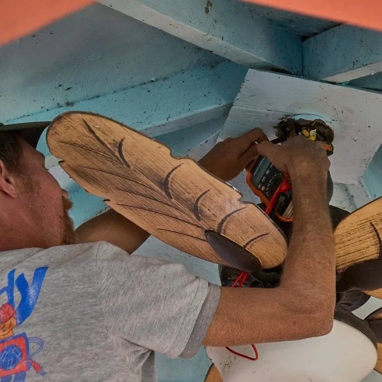 Ceiling fan installation showing tropical blade design and electrical wiring process improving airflow and interior style in Florida residence.