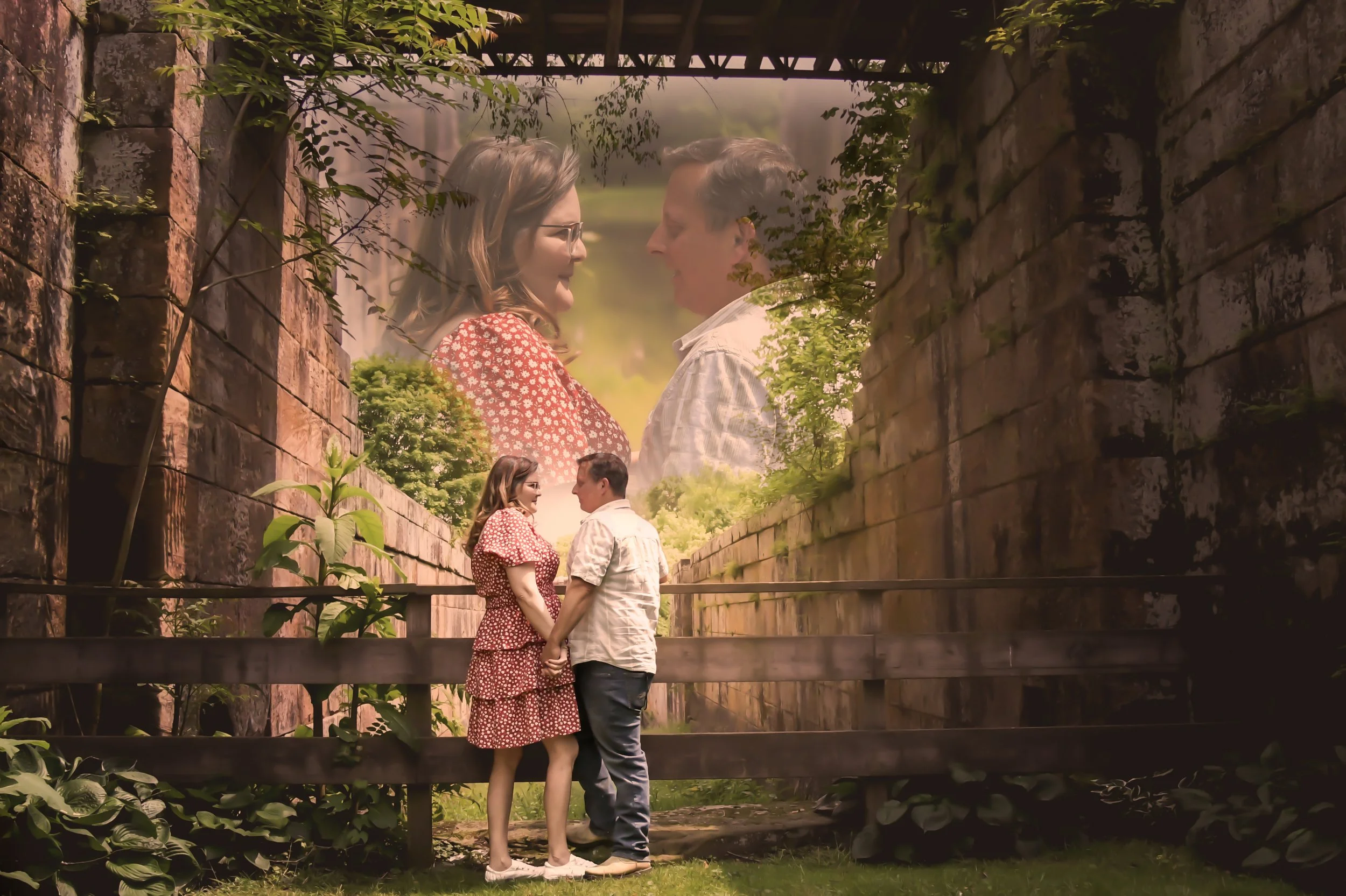 A couple holding hands in a lush green park surrounded by tall brick walls with an overlay of a larger, romantic image of the same couple facing each other, smiling, with trees and sky in the background.