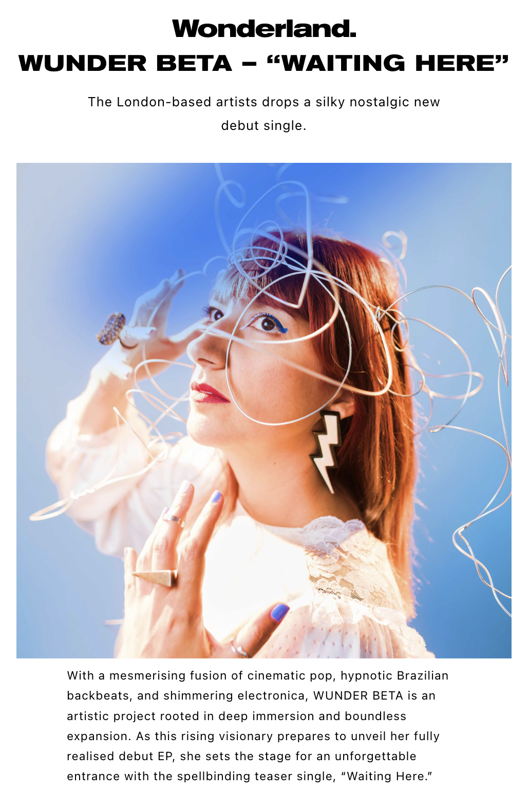 WUNDER BETA (Roberta Lucca) with bold makeup, wearing a white lace top and large lightning bolt earrings, is surrounded by swirling headpieces on a gradient blue background.