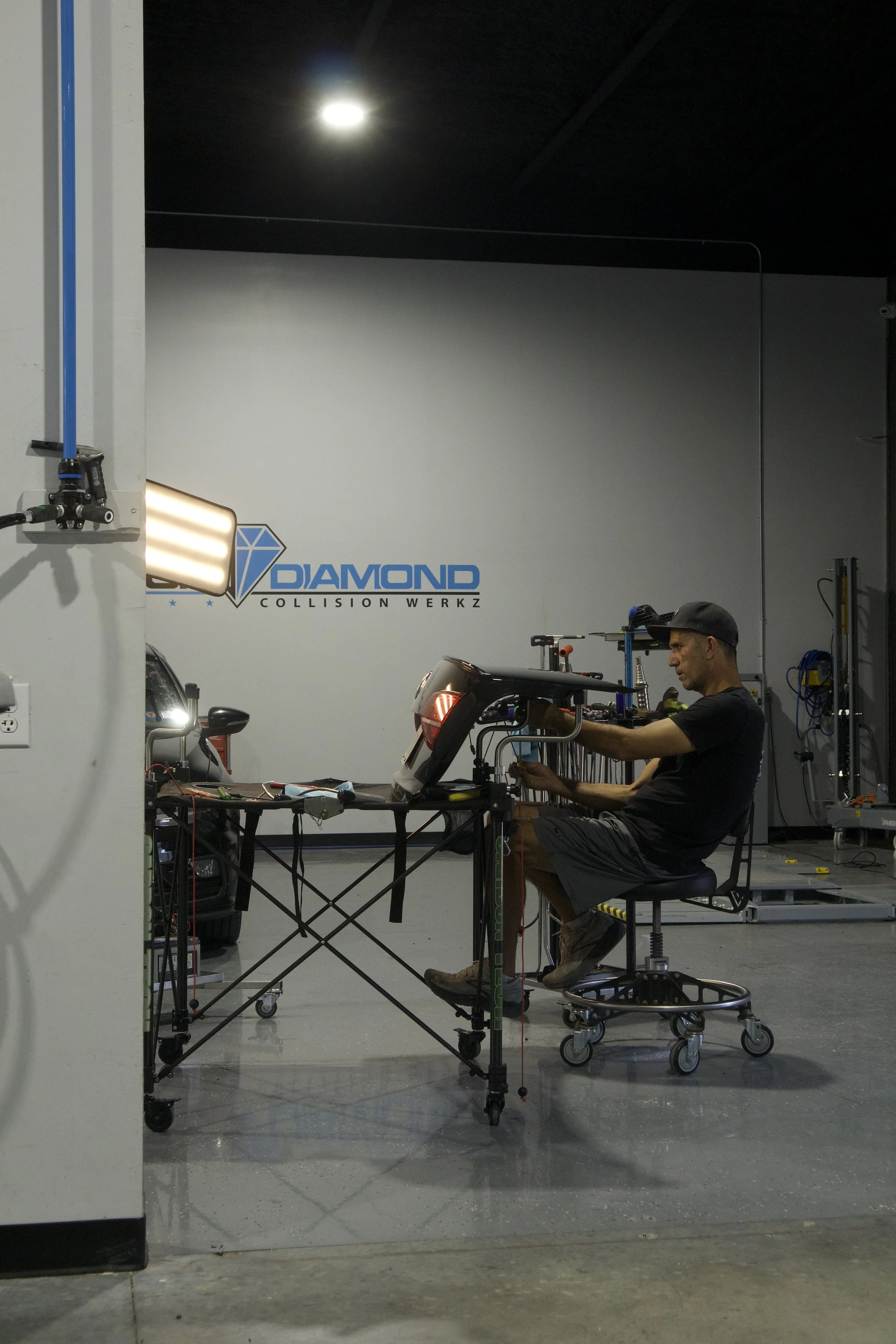 A skilled technician carefully repairing a vehicle panel in one of our repair bays.
