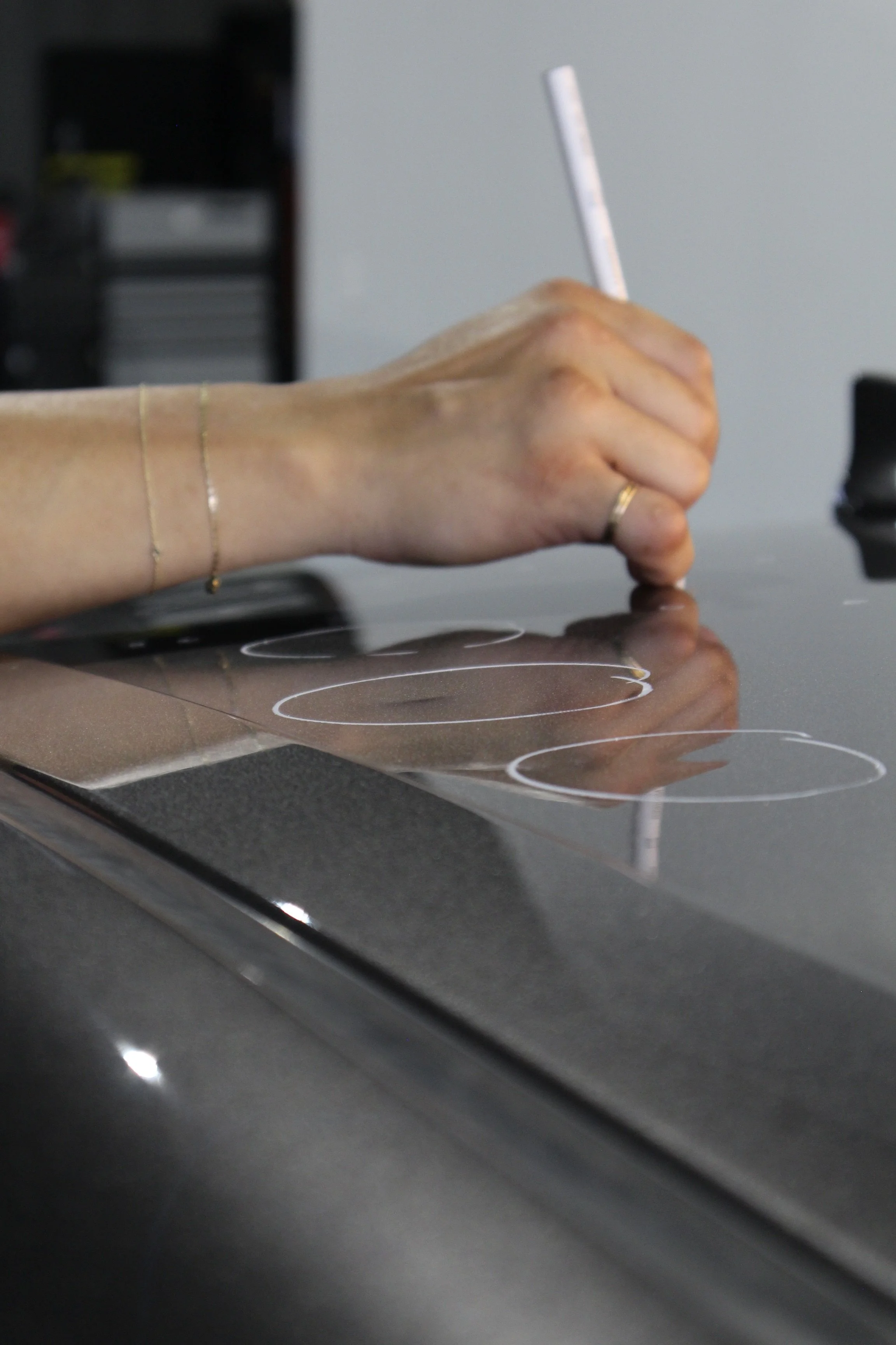 Estimator marking hail dents with a wax pencil to accurately count damage and ensure a complete repair plan.