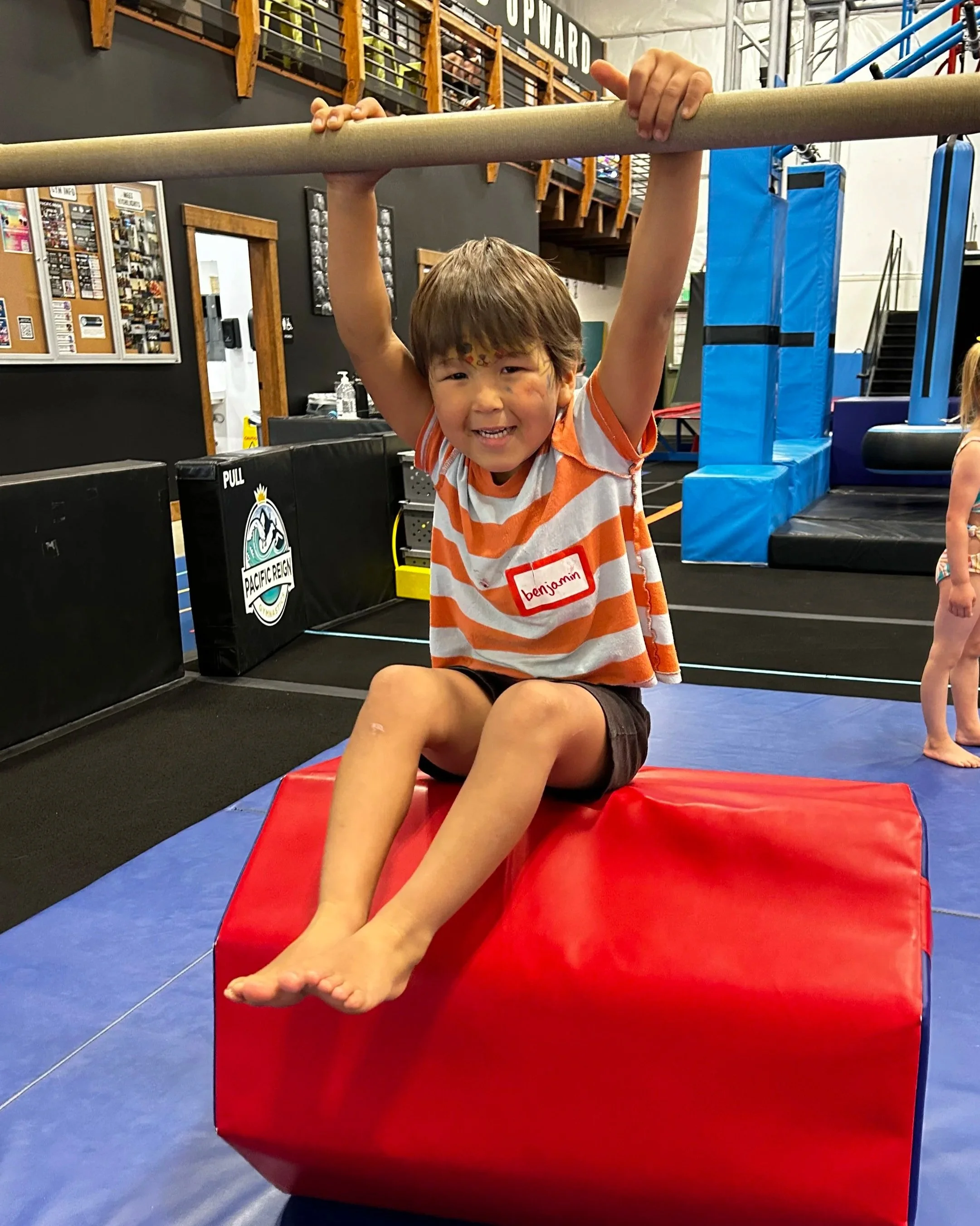 Young Boy playing on Bars at Gymnastics Summer Camp