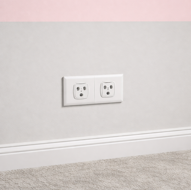 electrician measuring outlet spacing on living room wall