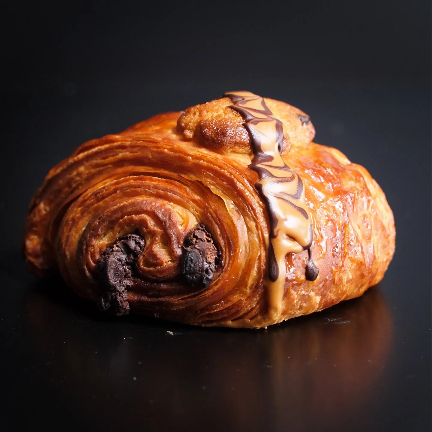 Chocolate Chip Cookie Pain au Chocolat 🍪✨

Buttery croissant dough filled with Whittaker&rsquo;s chocolate and chocolate chip cookie dough, brushed with espresso syrup, baked until golden and flaky, then finished with Biscoff and a chocolate drizzle