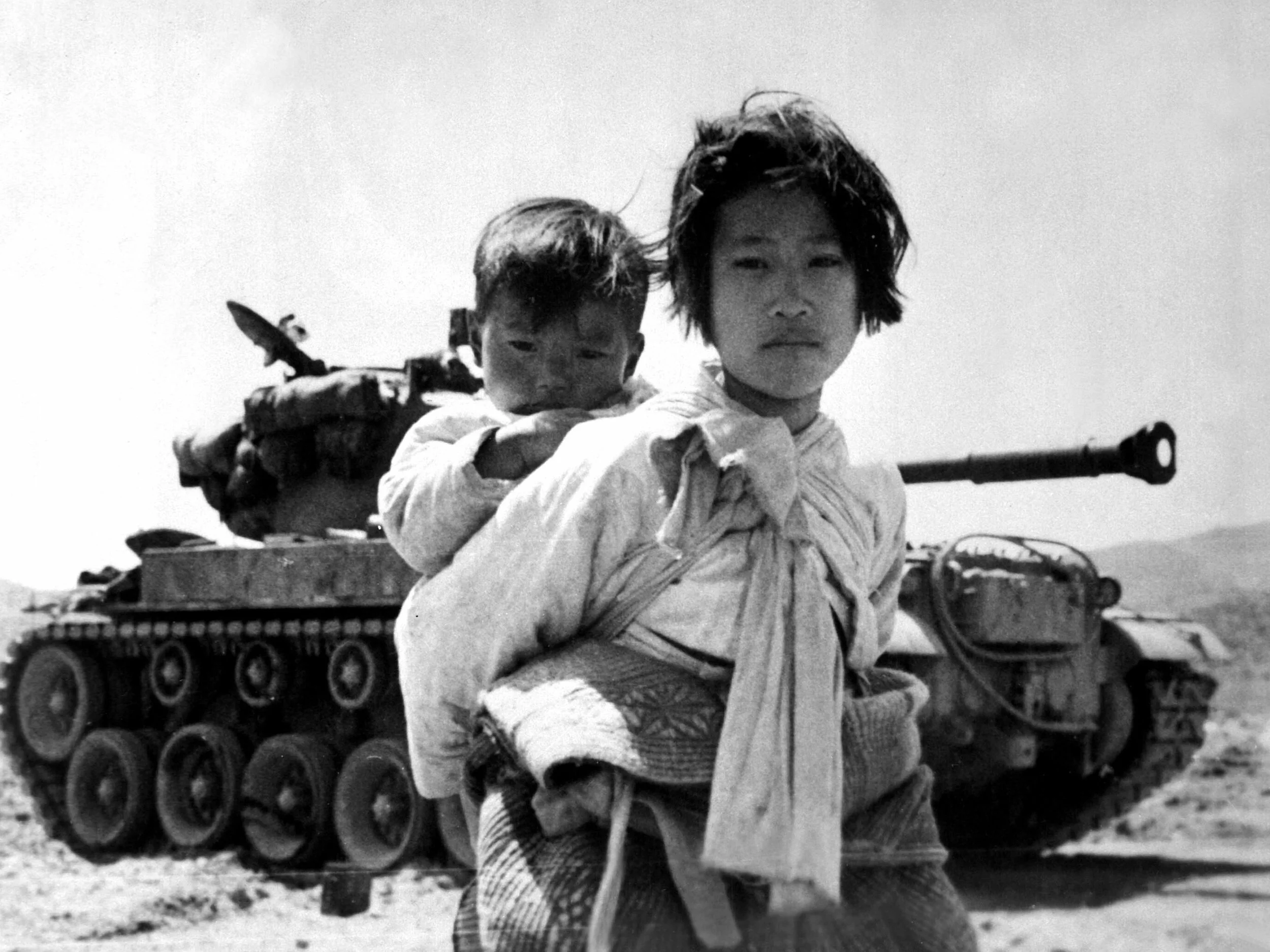 A war weary Korean girl carries her brother. 