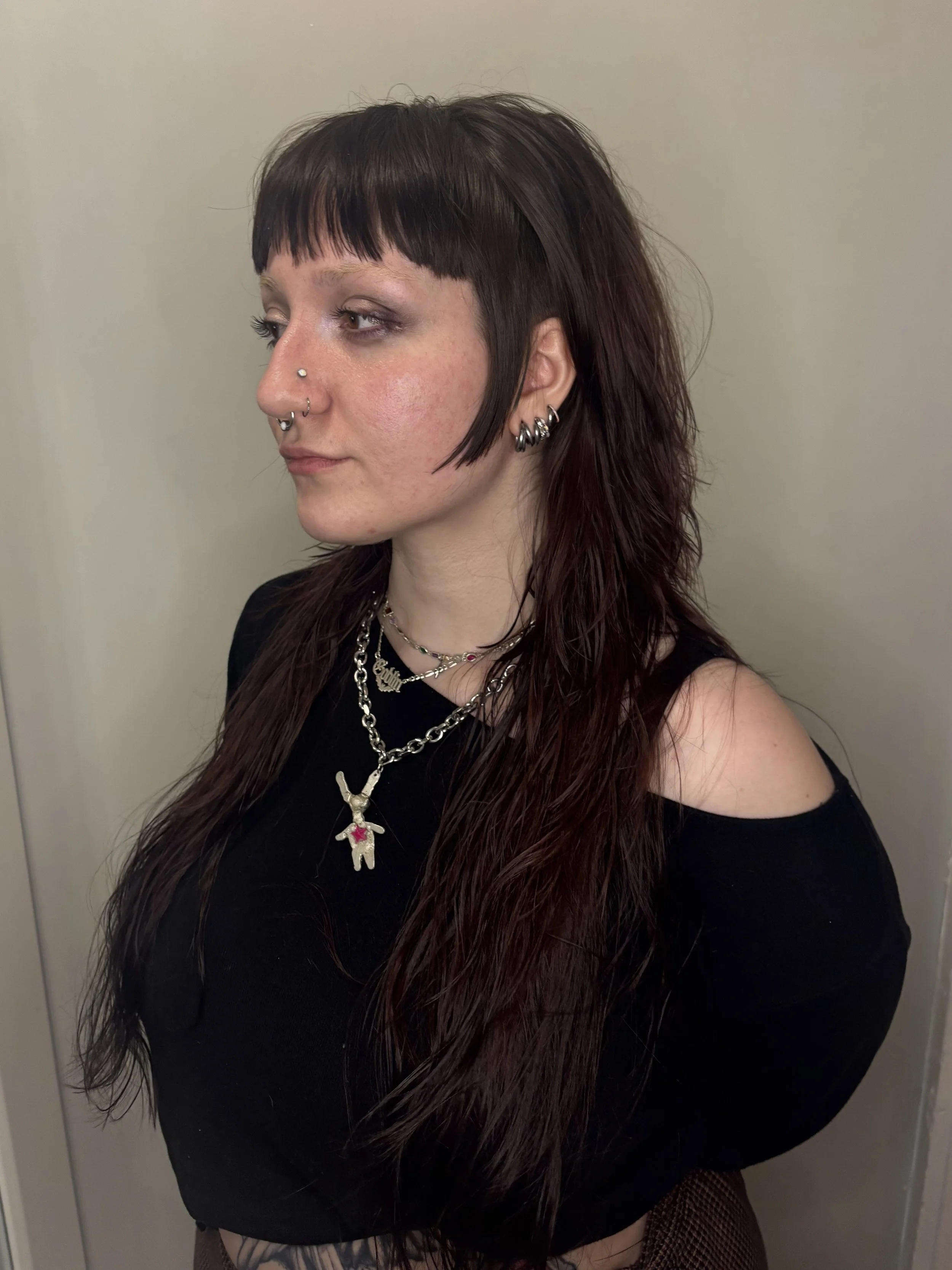 Dark brown, shoulder-length, and slightly wavy hair.