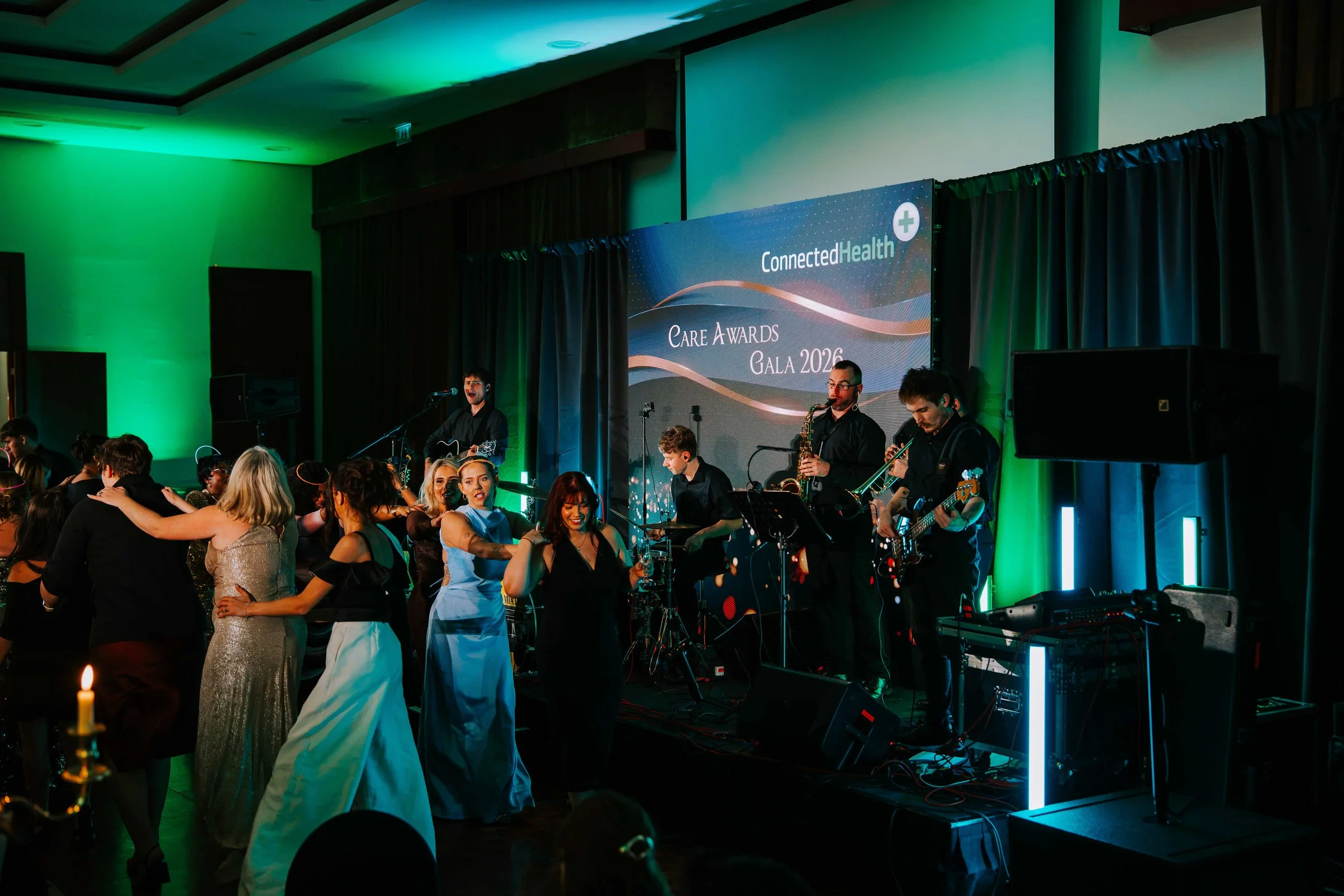Live band playing in front of the LED wall as guests form a dance line at the Connected Health awards