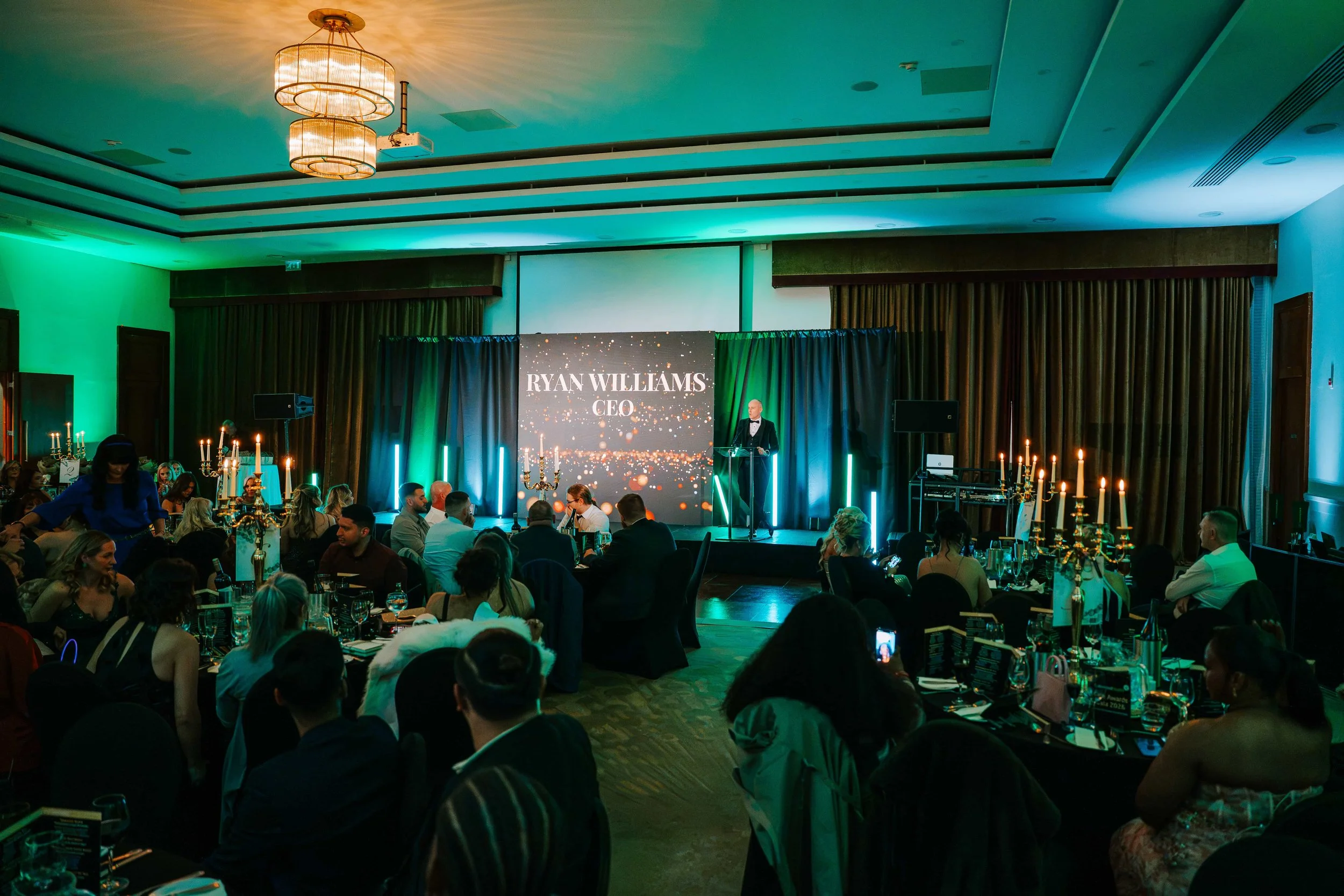 Full Somerville suite at CityNorth Hotel during the CEO's speech, with candlelit tables and green uplighting