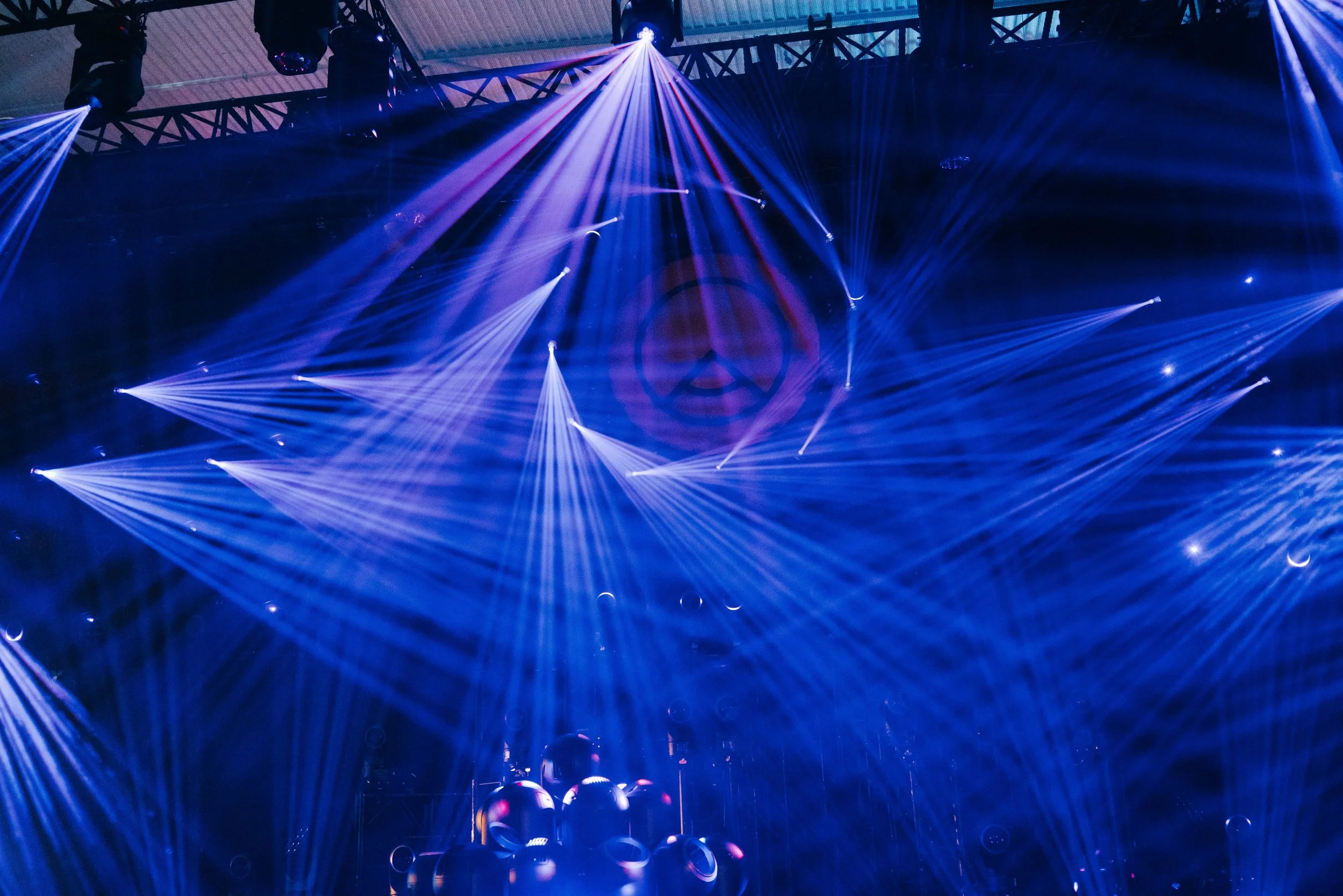 An indoor event with colorful laser lights and beams creating a dynamic visual display.