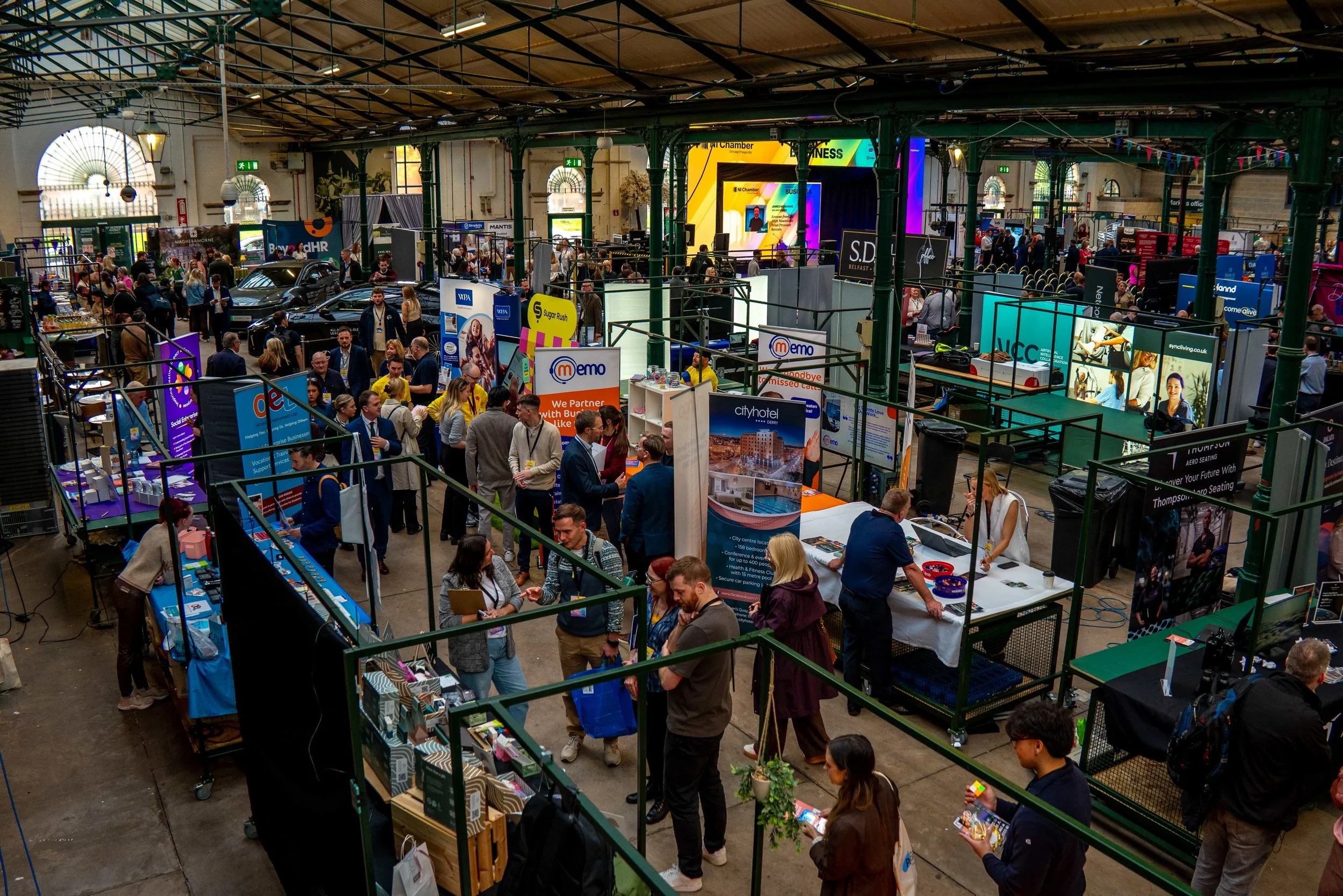Overhead view of the exhibitor marketplace at St George's Market, with the LED arch stage in the background