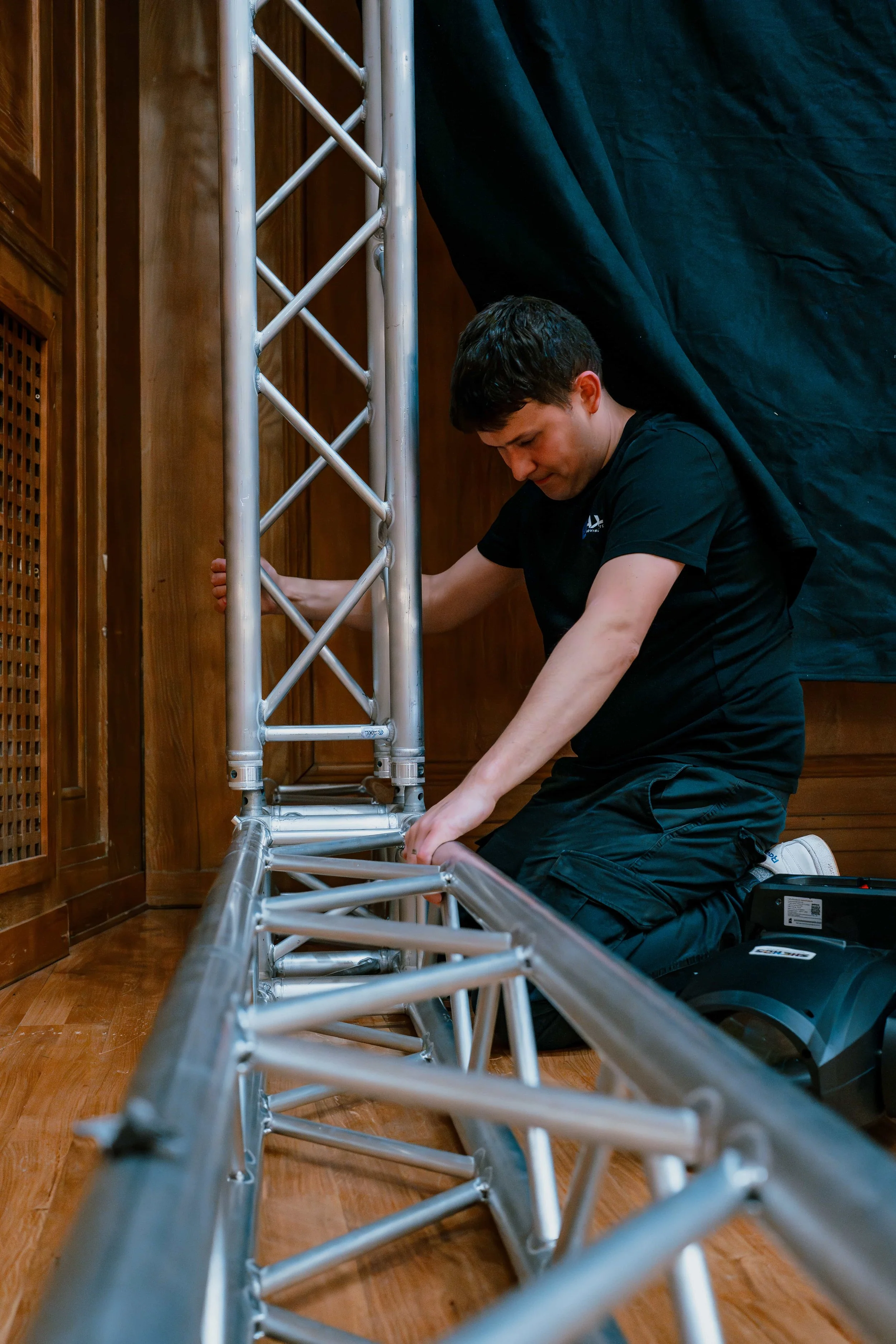 Event crew assembling a ground-support truss tower during a corporate event build