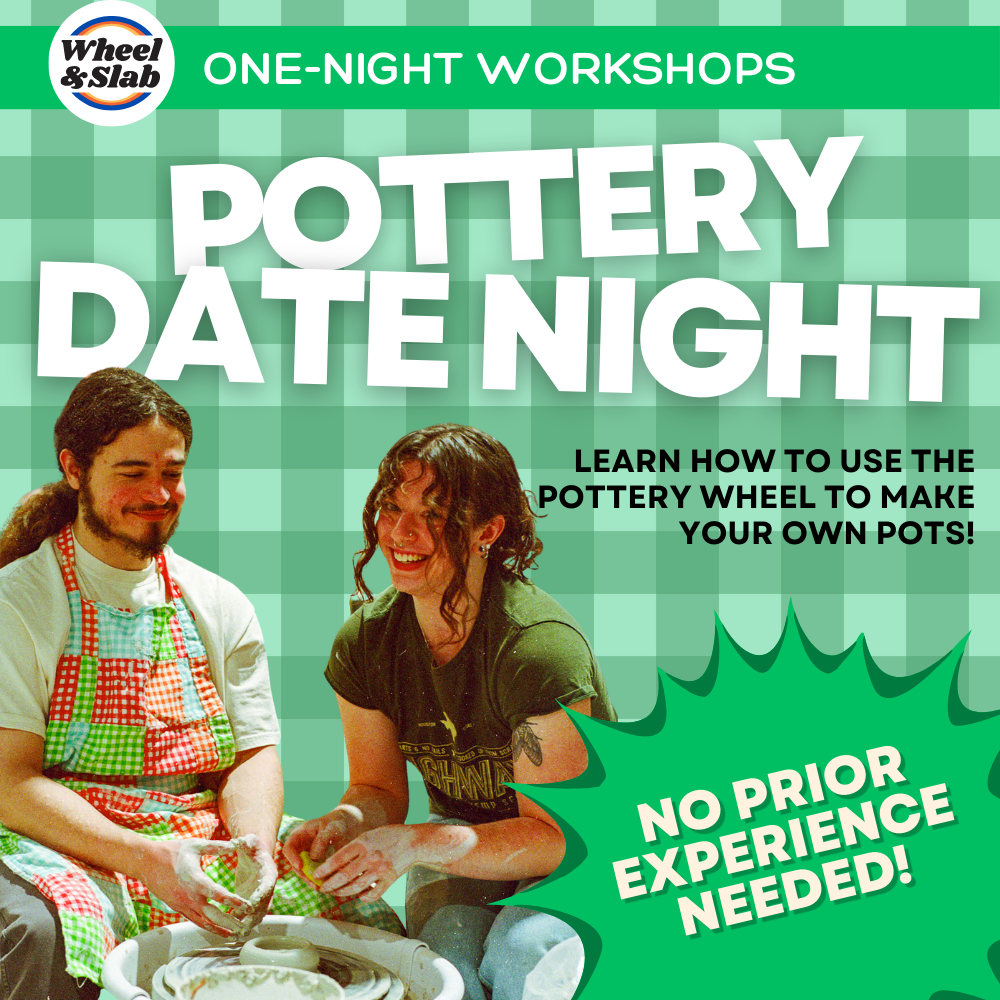 A couple sit at a pottery wheel,  smiling at the camera.