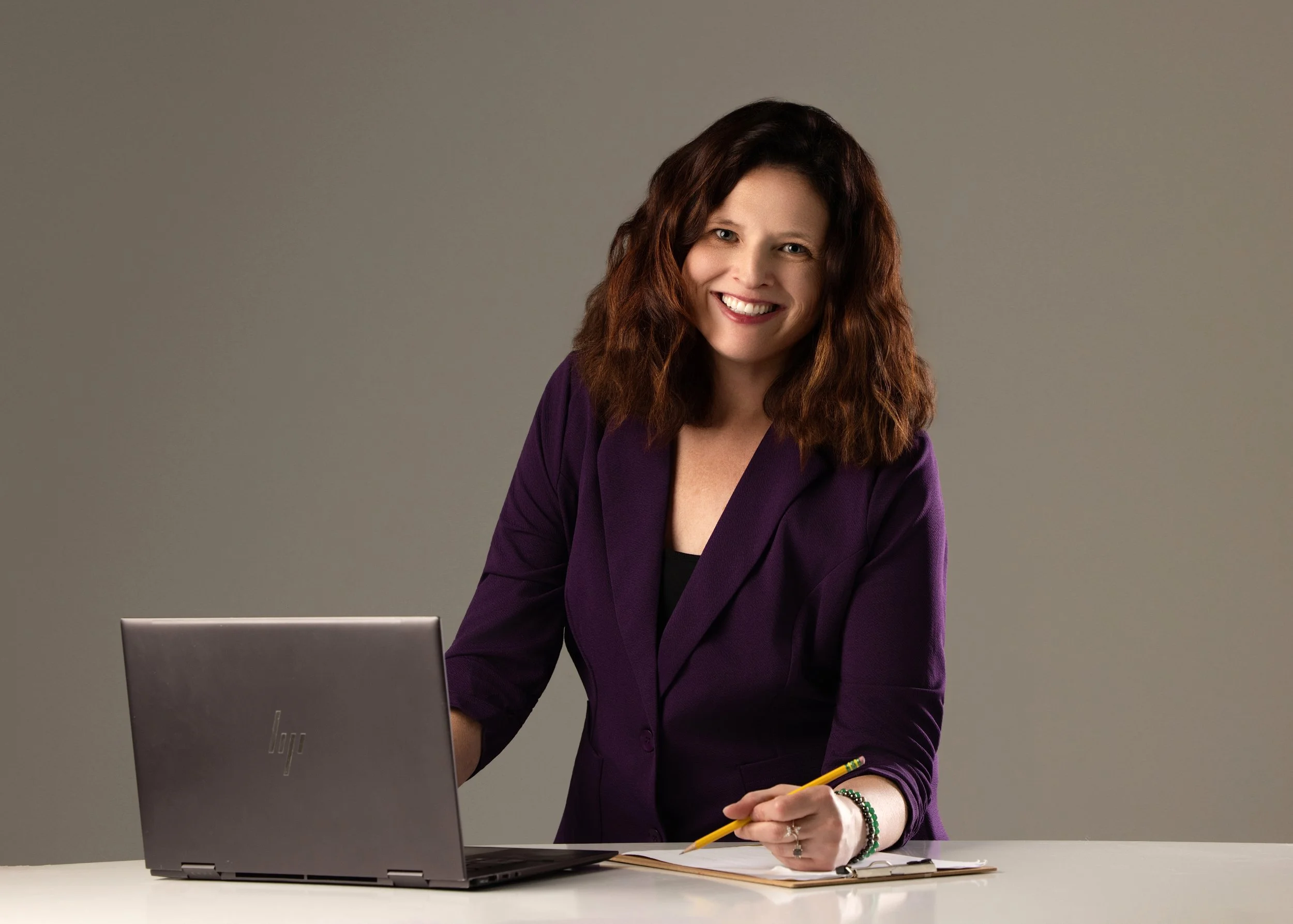 Katrina Boyd, LCSW, smiling at her computer while providing online therapy and telehealth counseling services for clients in Indiana.
