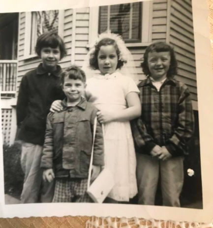 A group of four children in front of a house in the late 1950's