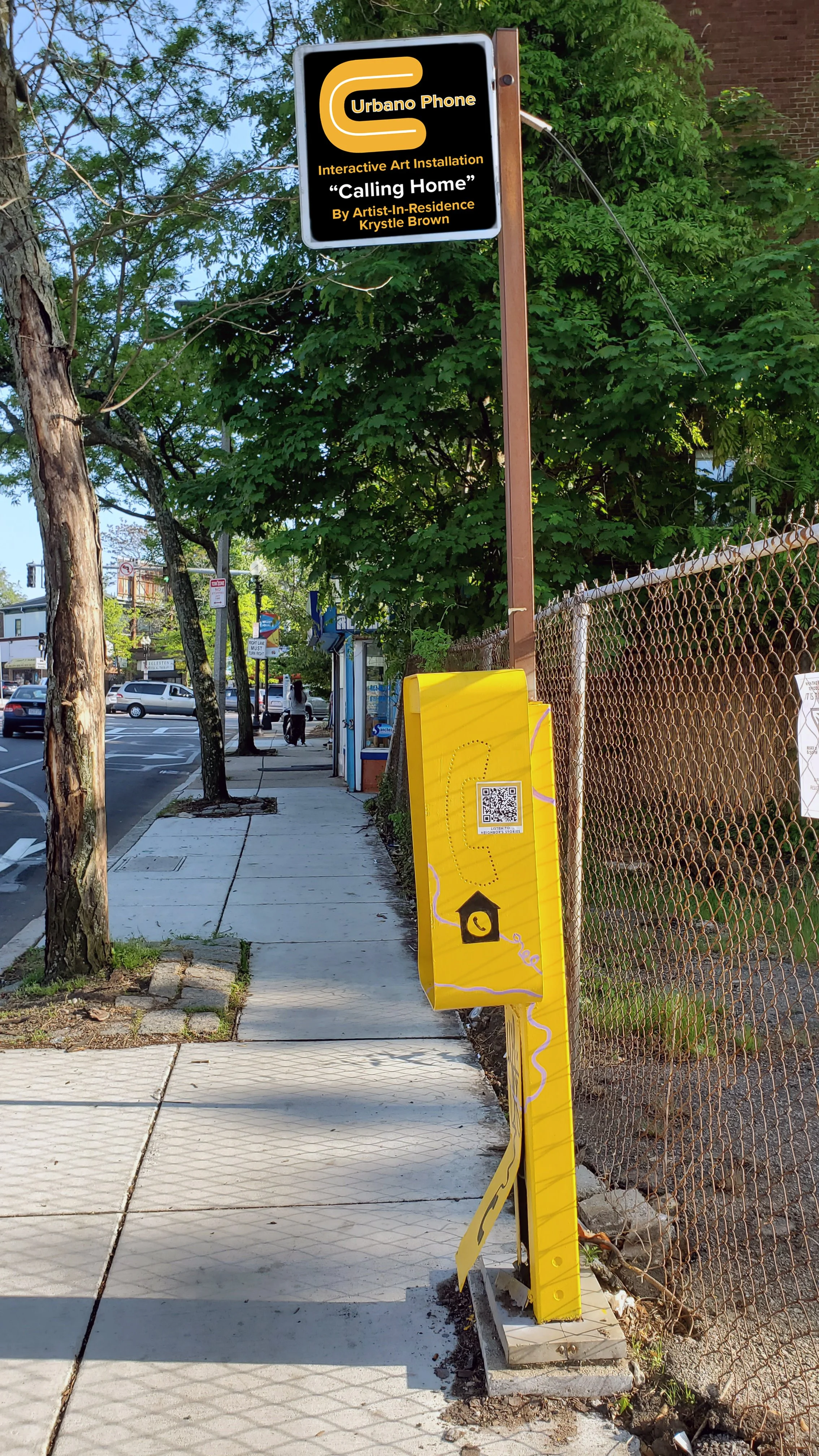 A side view of a yellow painted phonebooth