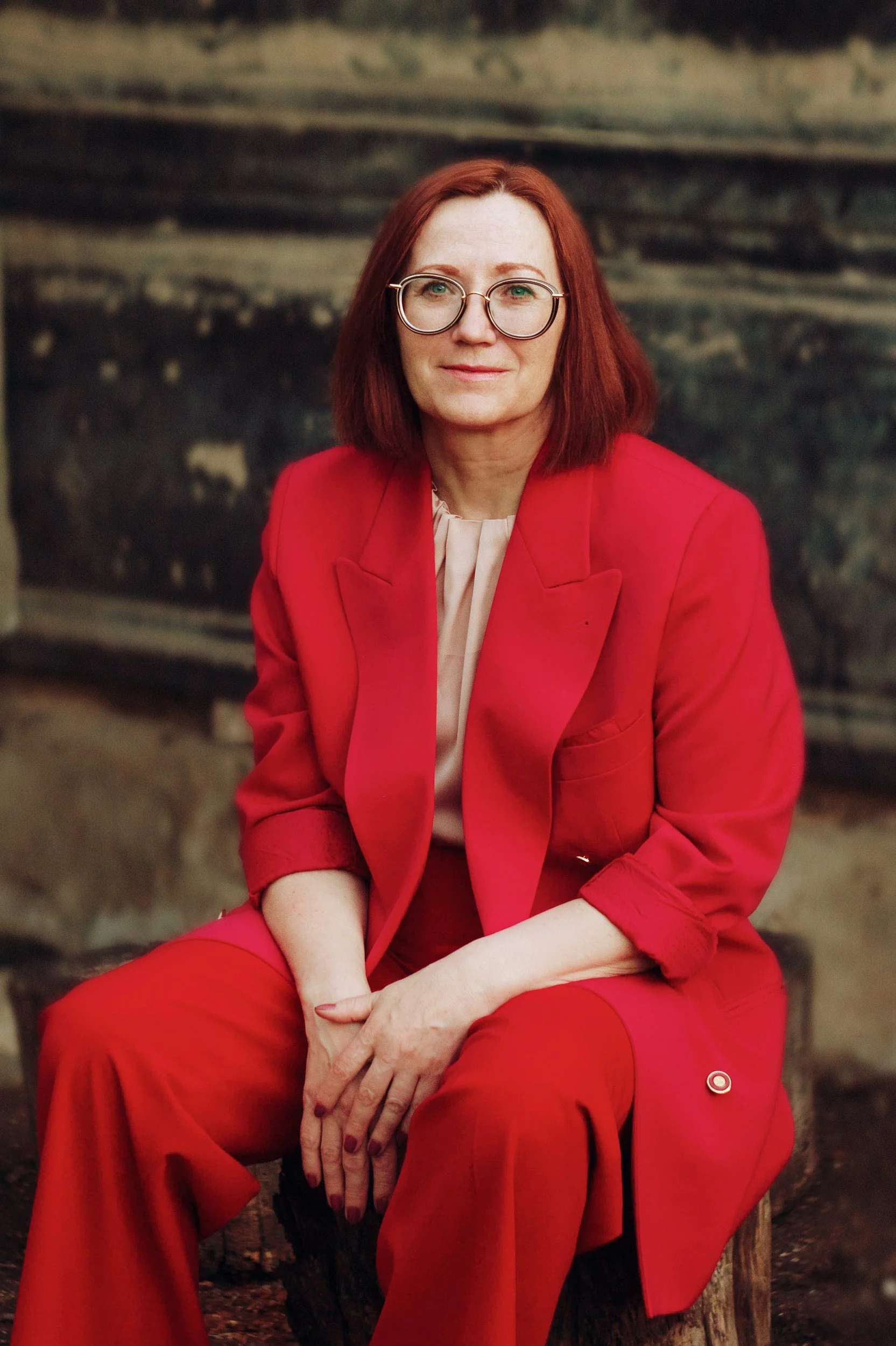 White woman with short red hair and glasses wearing a red suit, looking thoughtfully at the camera, representing midlife binge eating recovery and therapy in the San Francisco Bay Area | 94301 94025 94027