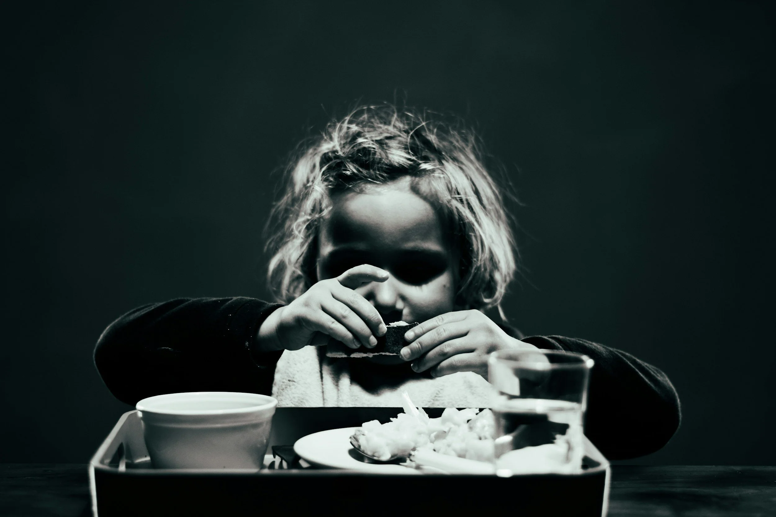 Black-and-white photo of girl struggling to eat | what to do when your child struggles with picky eating in California | ARFID therapy San Diego | 92127 | 92014 | 93924 |
