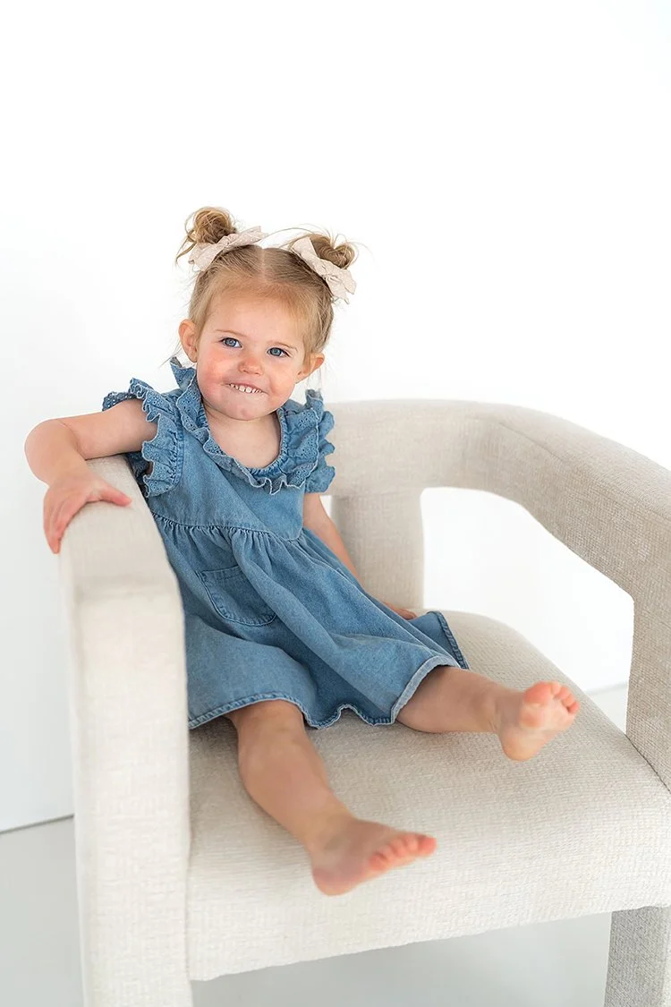 A toddler enjoying her studio portrait session, smiling and showcasing who she is