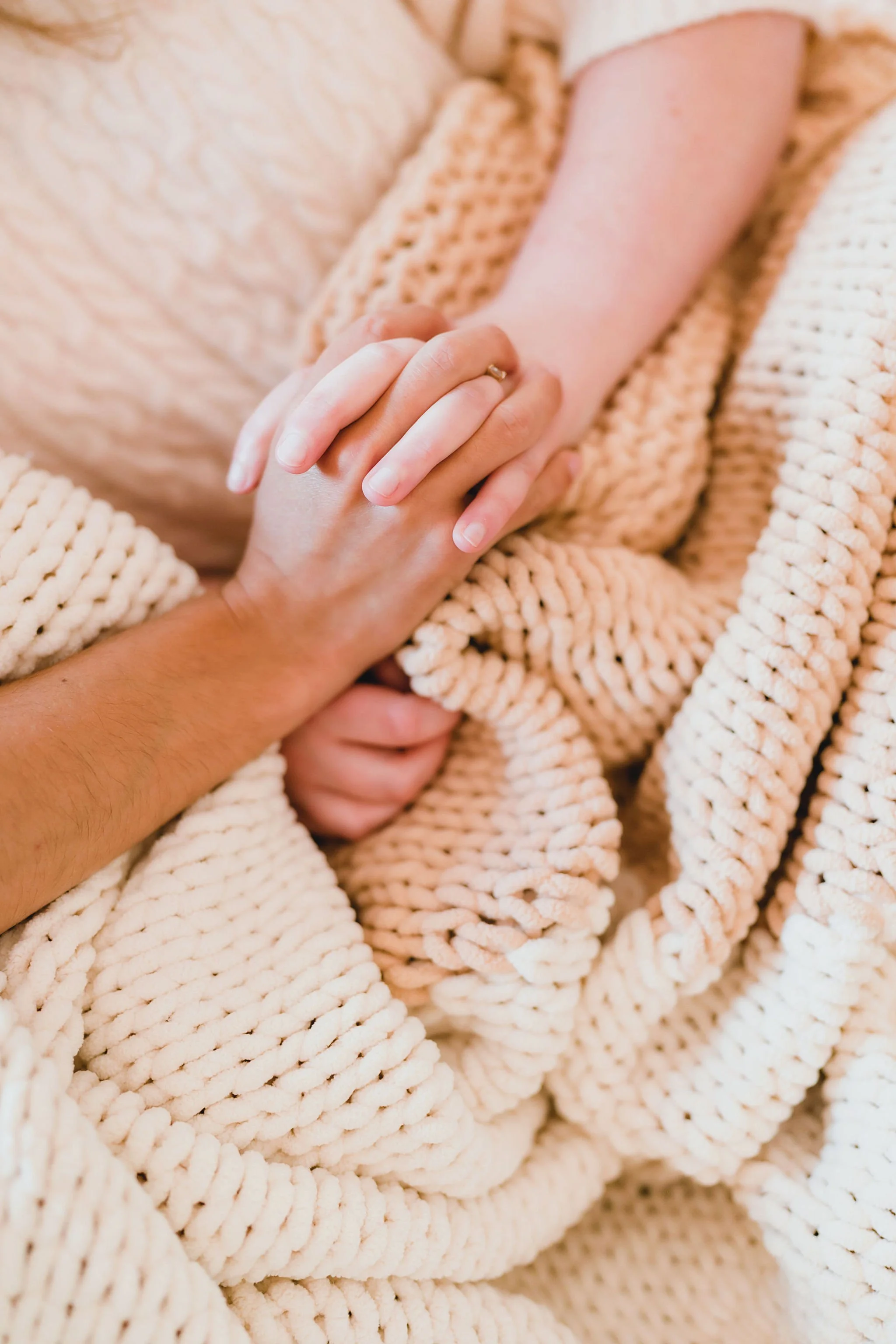 Close lifestyle shot of couple hands holding soft knit blanket texture
