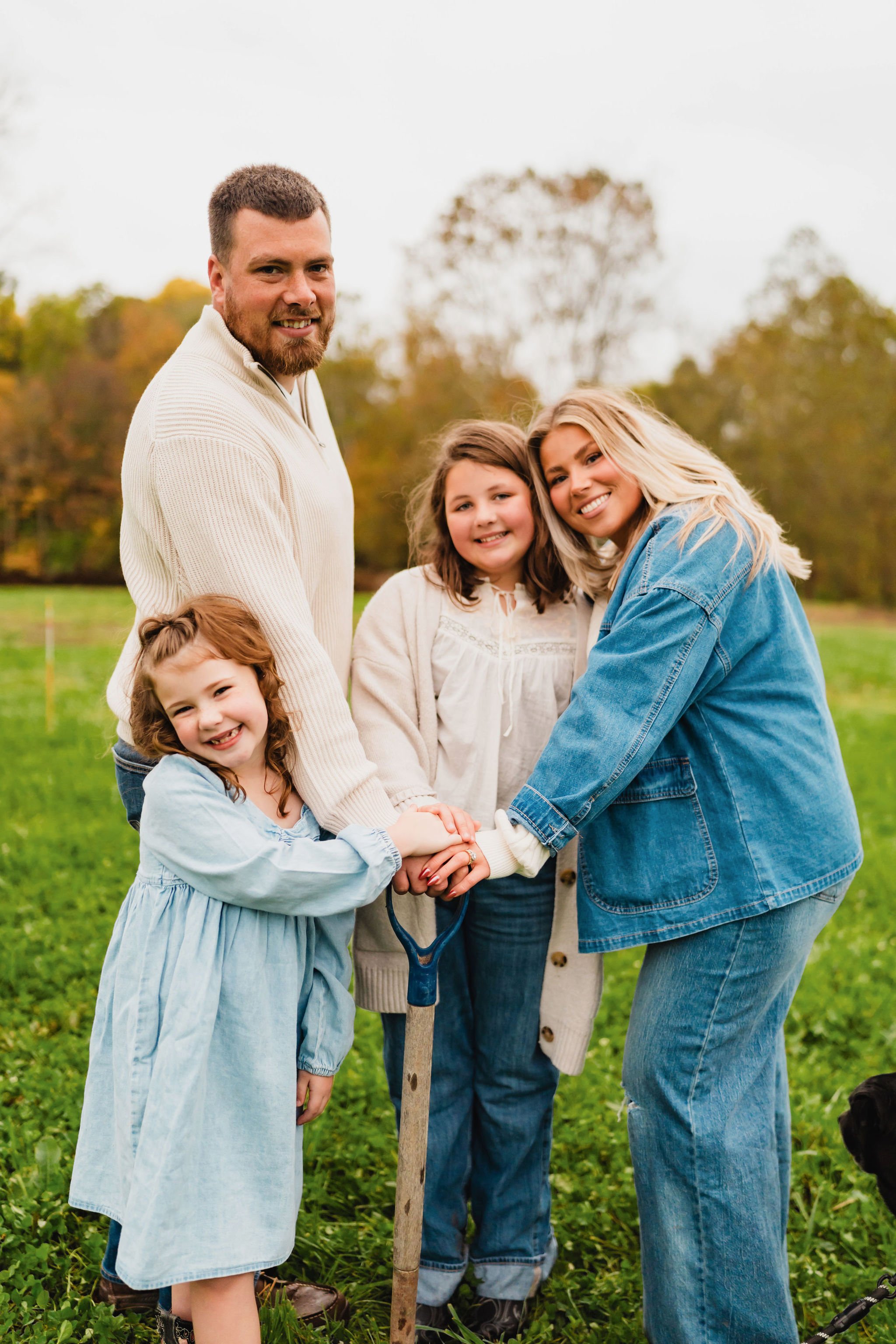 Family gathered around a shovel on the land where their future home will stand.