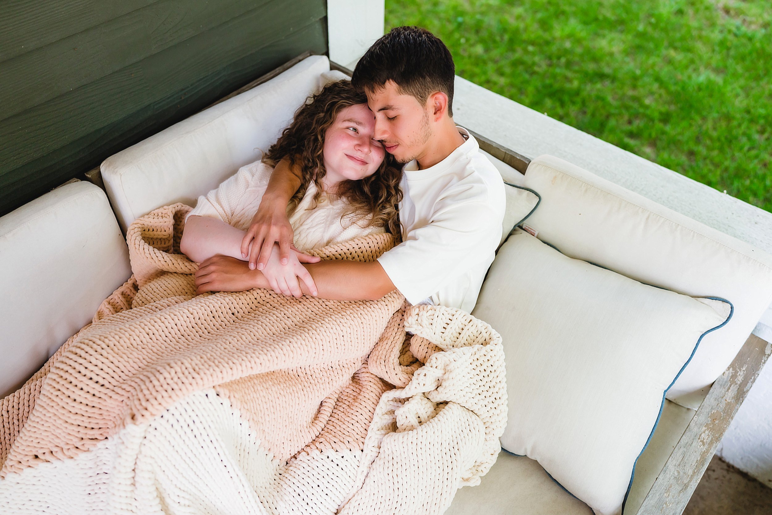 Couple sharing quiet moment wrapped in soft neutral knit blankets during lifestyle shoot