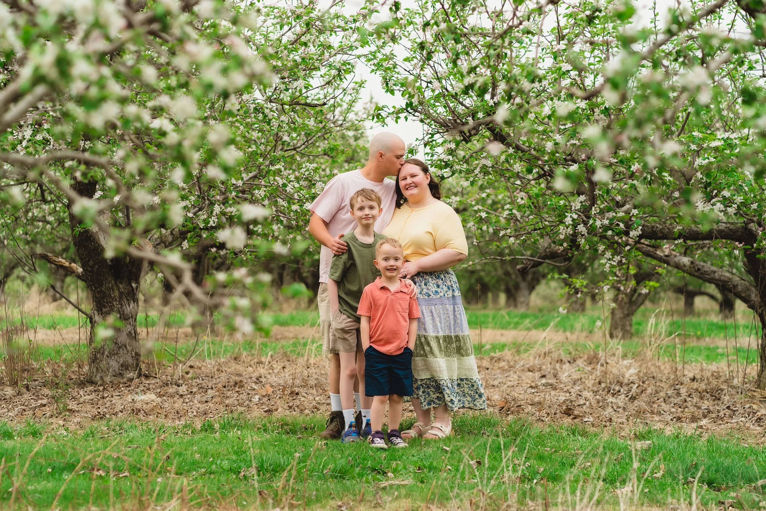 family photo session in Indiana orchard with kids playing and dancing