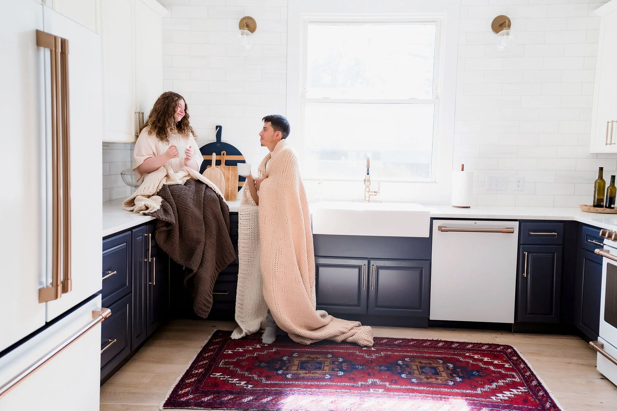 Couple sharing quiet moment wrapped in soft neutral knit blankets during lifestyle shoot