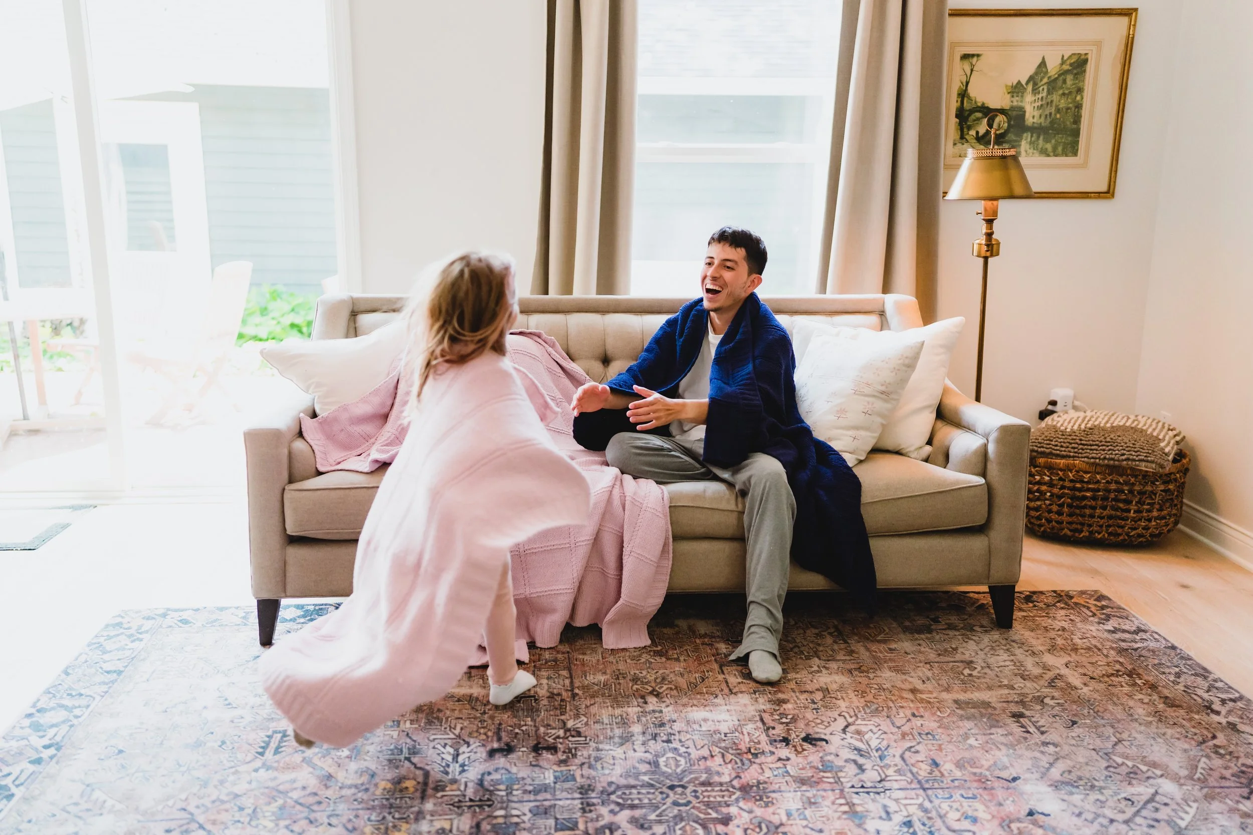 Authentic in-home moment showing connection and comfort with Little Giraffe blankets
