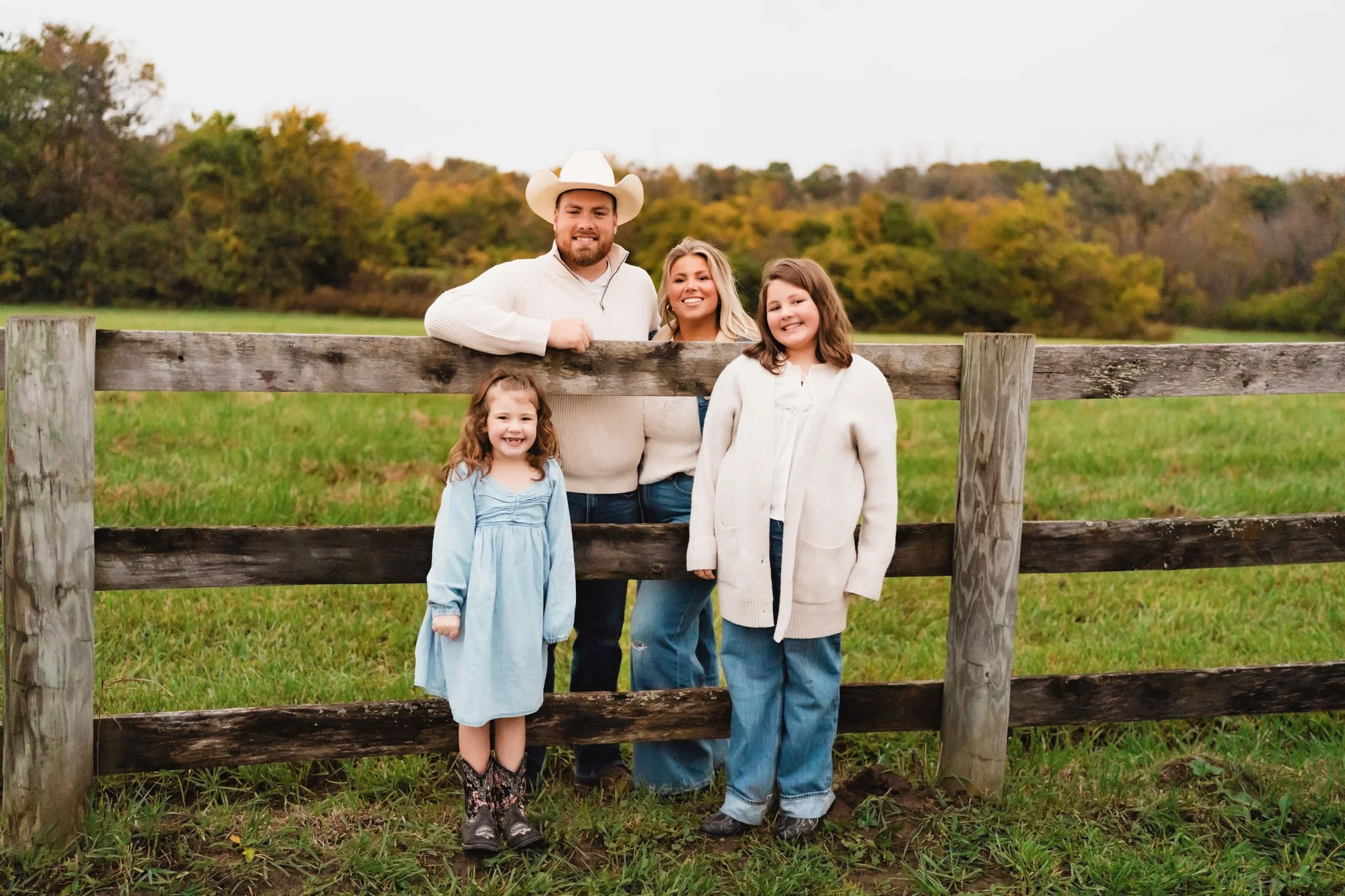 Family standing together at the fence on their property before building their home in Indiana.