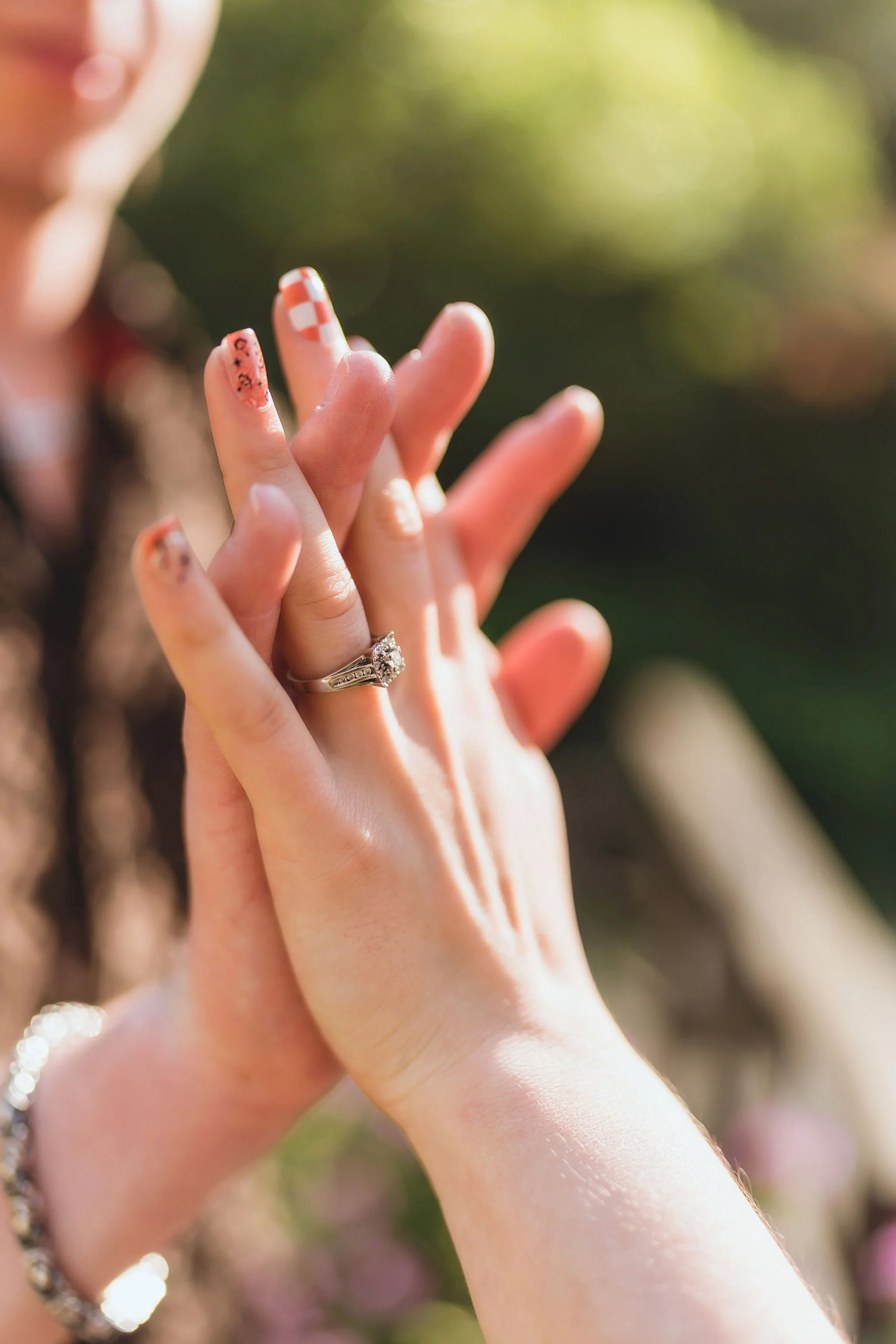 A detail photo showing off the engagement ring as the couple joins hands